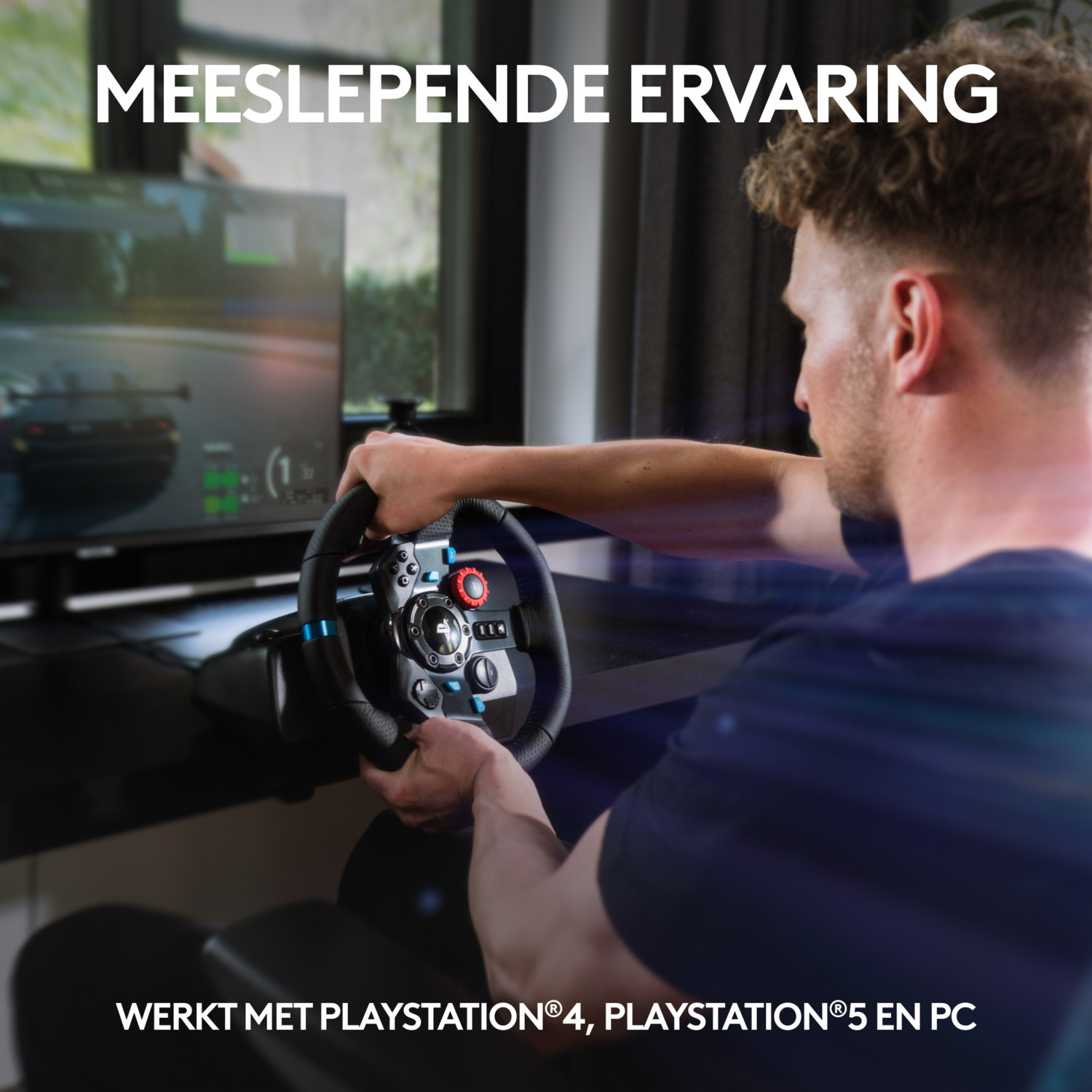 Man playing a racing game with a steering wheel and monitor.