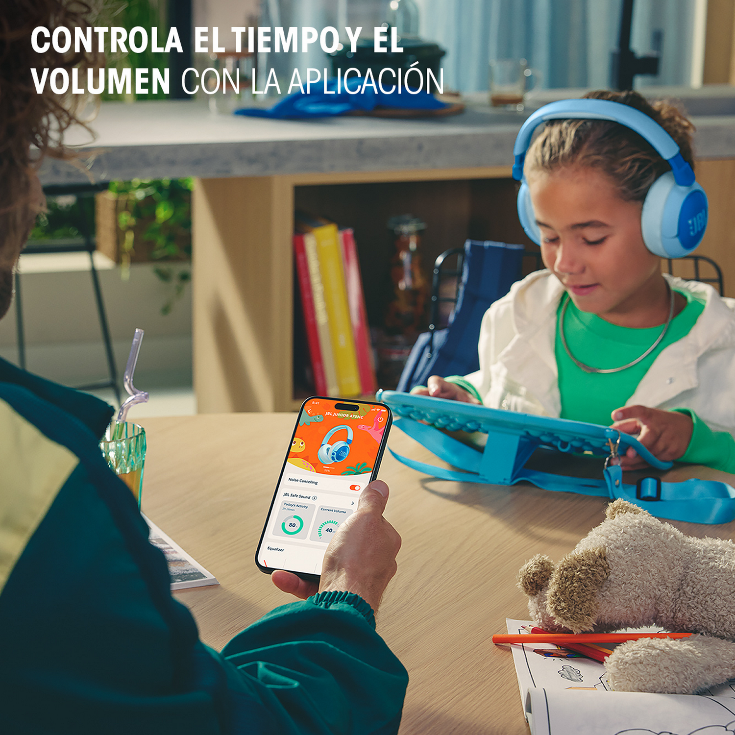 Un padre muestra a su hijo cómo usar los auriculares con una tableta, con texto en español.