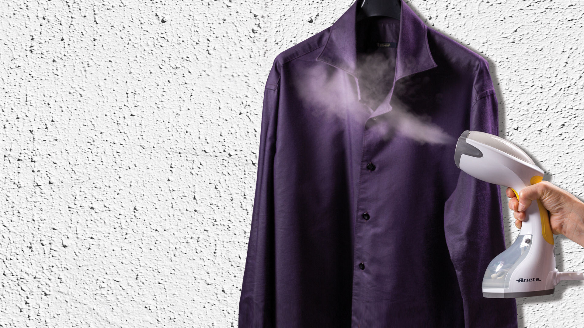 Koszula prasowana parą za pomocą parownicy ręcznej, białe tło.