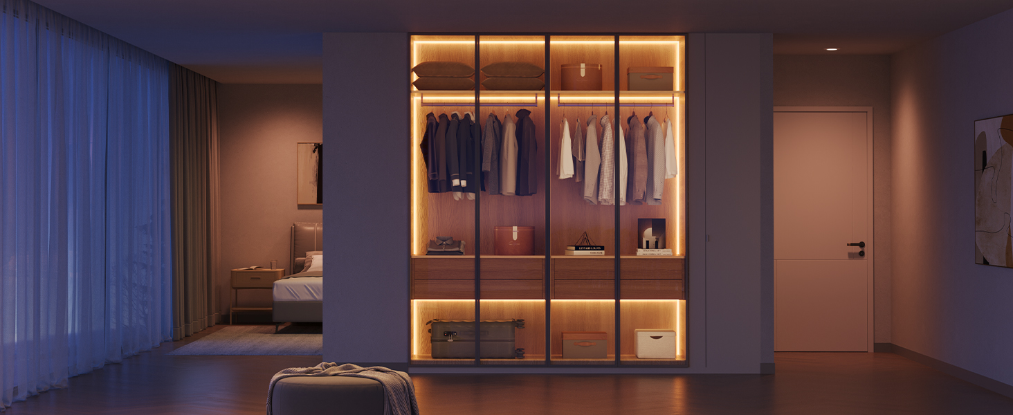 Ein Kleiderschrank ist mit Kleidung im Inneren beleuchtet. Ein Bett ist im Hintergrund sichtbar, mit einer Tür rechts.