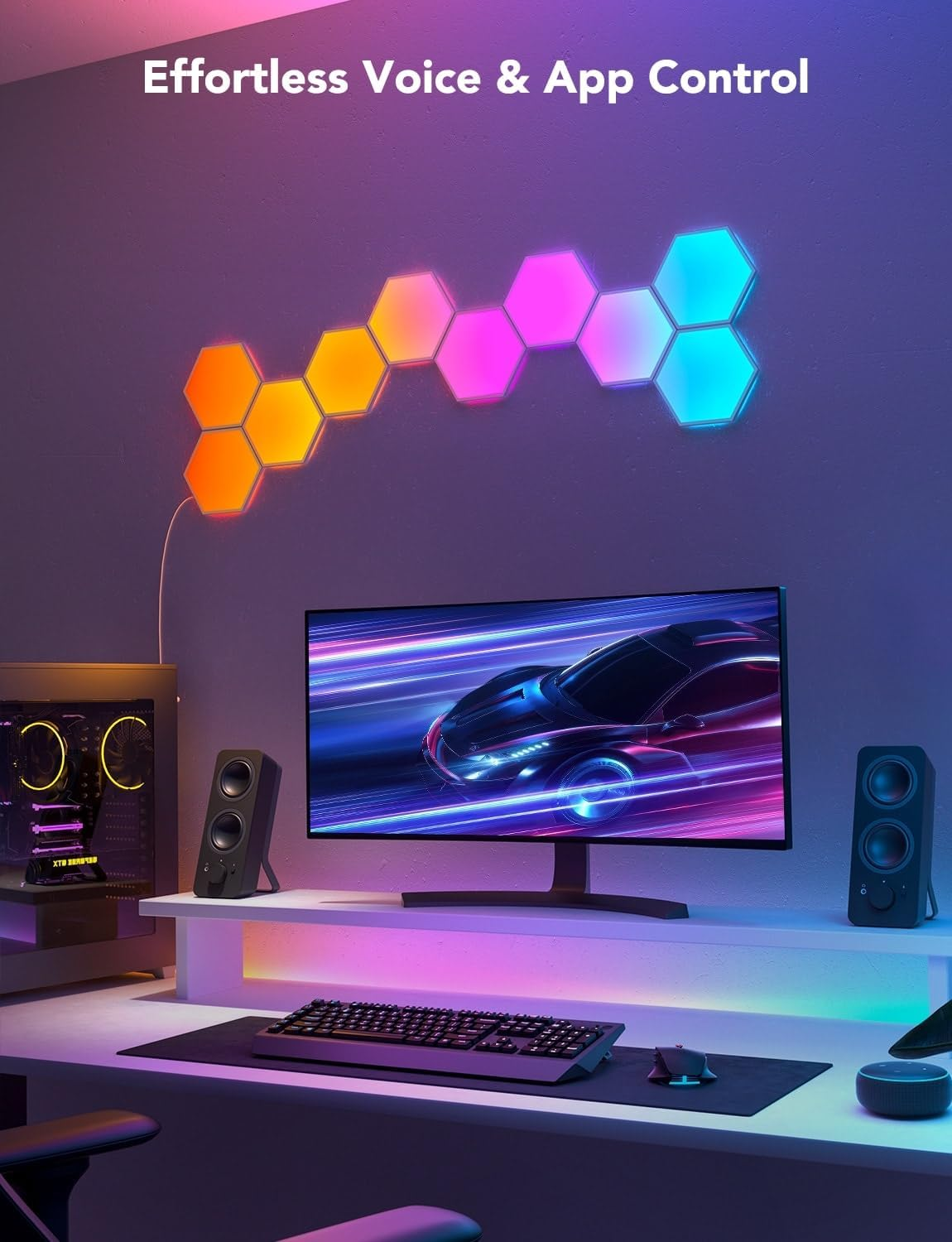 Schreibtisch-Setup mit sechseckigen Lichtern, Monitor, Lautsprechern und Computer.