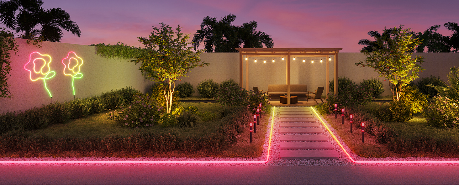 Beleuchteter Garten in der Abenddämmerung. Neonblumen, ein Weg und eine Holzpergola mit Lichtern.
