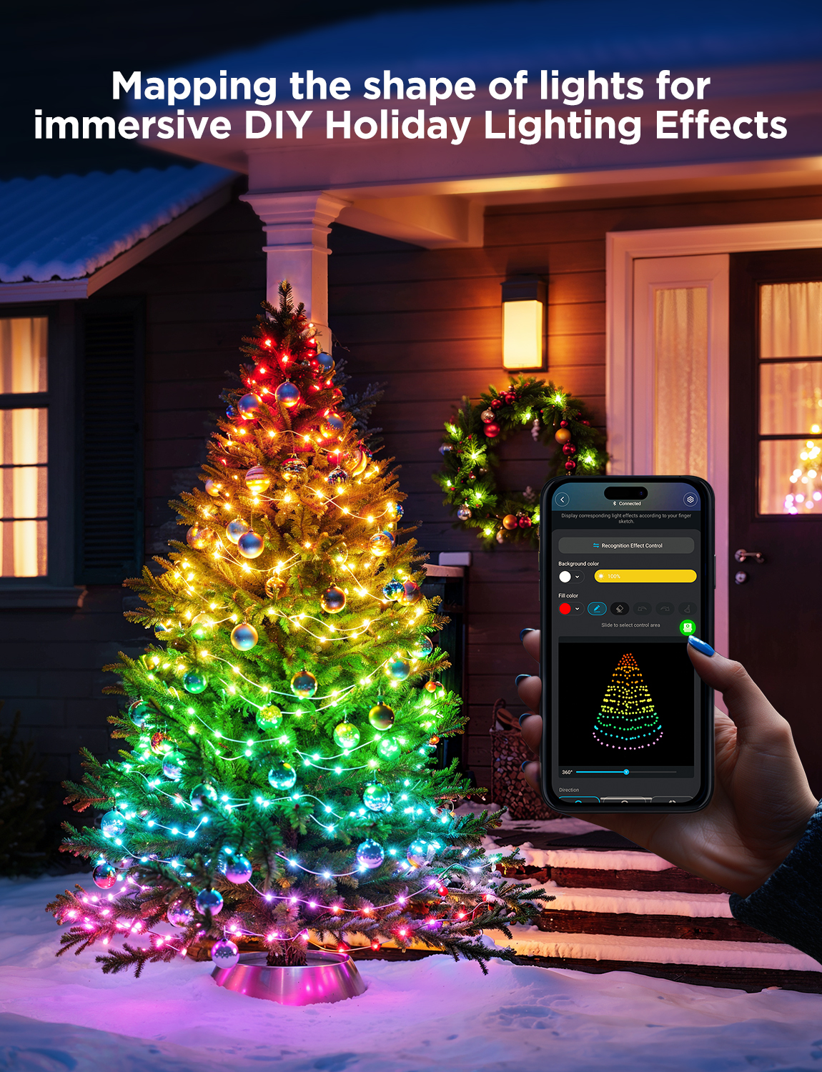 Ein bunter Weihnachtsbaum mit intelligenten Lichtern, eine Hand mit Telefon und App, verschneite Szene.