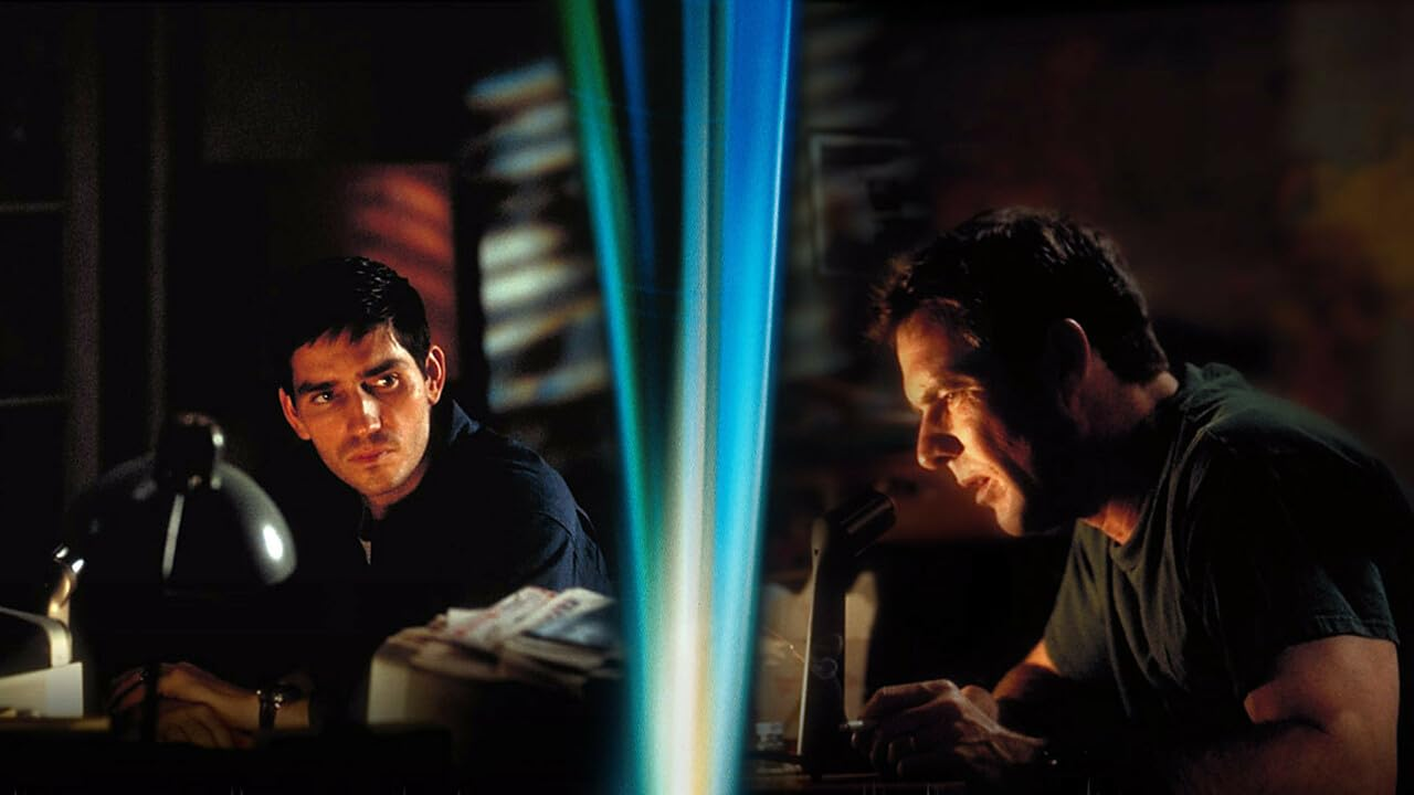 Twee mannen, de ene kijkt naar de andere, die kijkt naar een helder, verticaal licht. Donkere kantooromgeving.