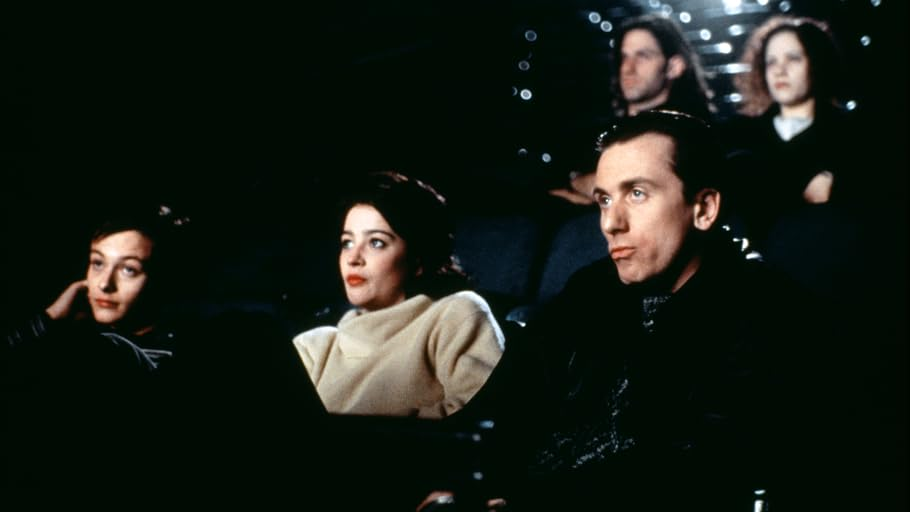 Des gens regardent un film dans une salle obscure. L'attention est portée sur le public.