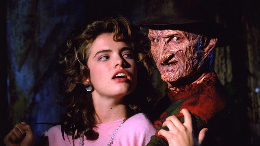 Freddy Krueger avec une femme. Il touche son épaule ; ils sont dans un cadre sombre et menaçant.