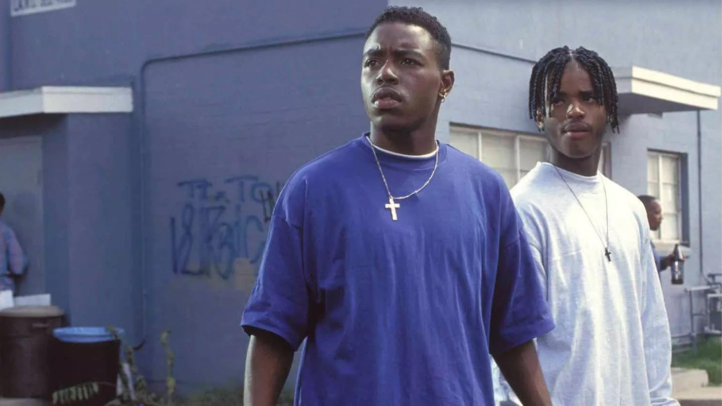 Deux jeunes hommes noirs regardant hors champ. L'un porte une chemise bleue, l'autre un sweat-shirt gris.