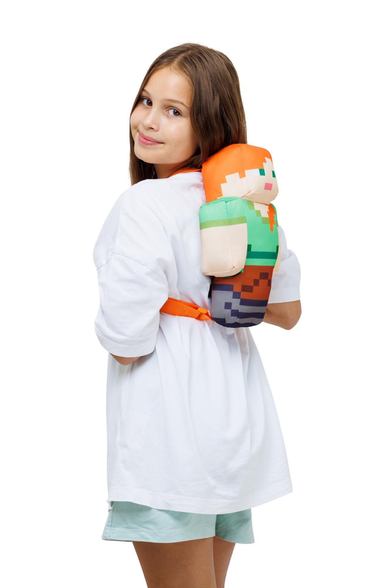 Ein Mädchen, das einen Minecraft Alex Rucksack trägt, lächelt in die Kamera.