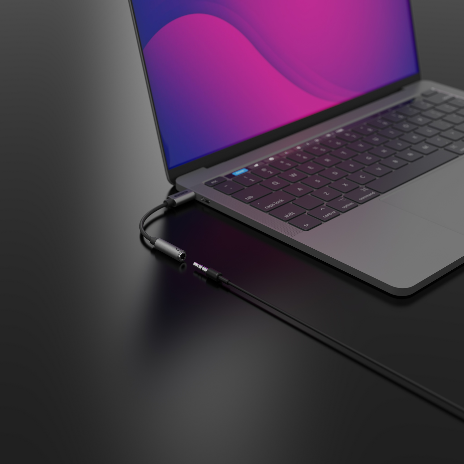 Ordinateur portable avec écran violet connecté à un câble audio noir sur une surface noire. Clavier visible.