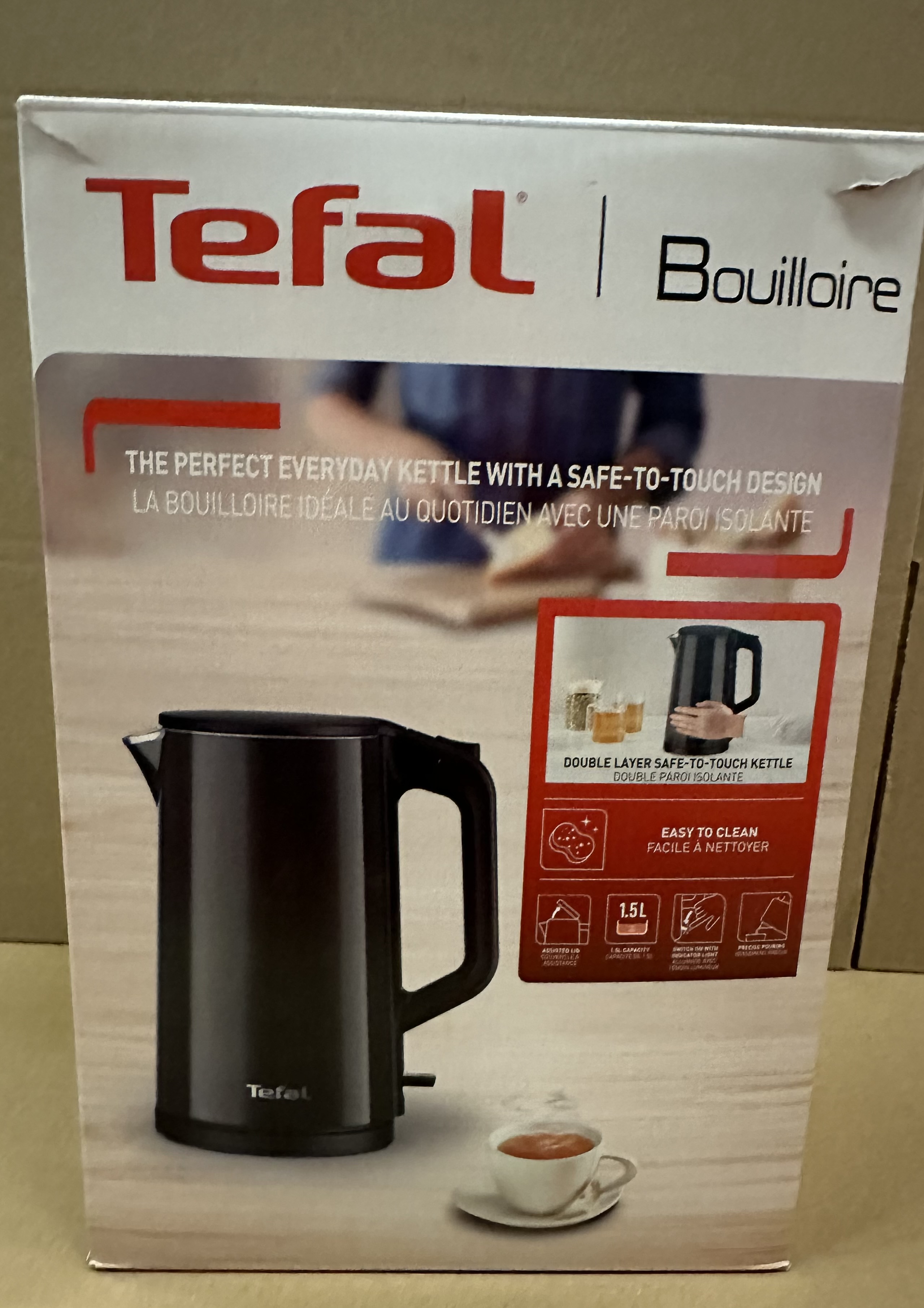 Czajnik Tefal w kolorze czarnym z filiżanką herbaty obok.