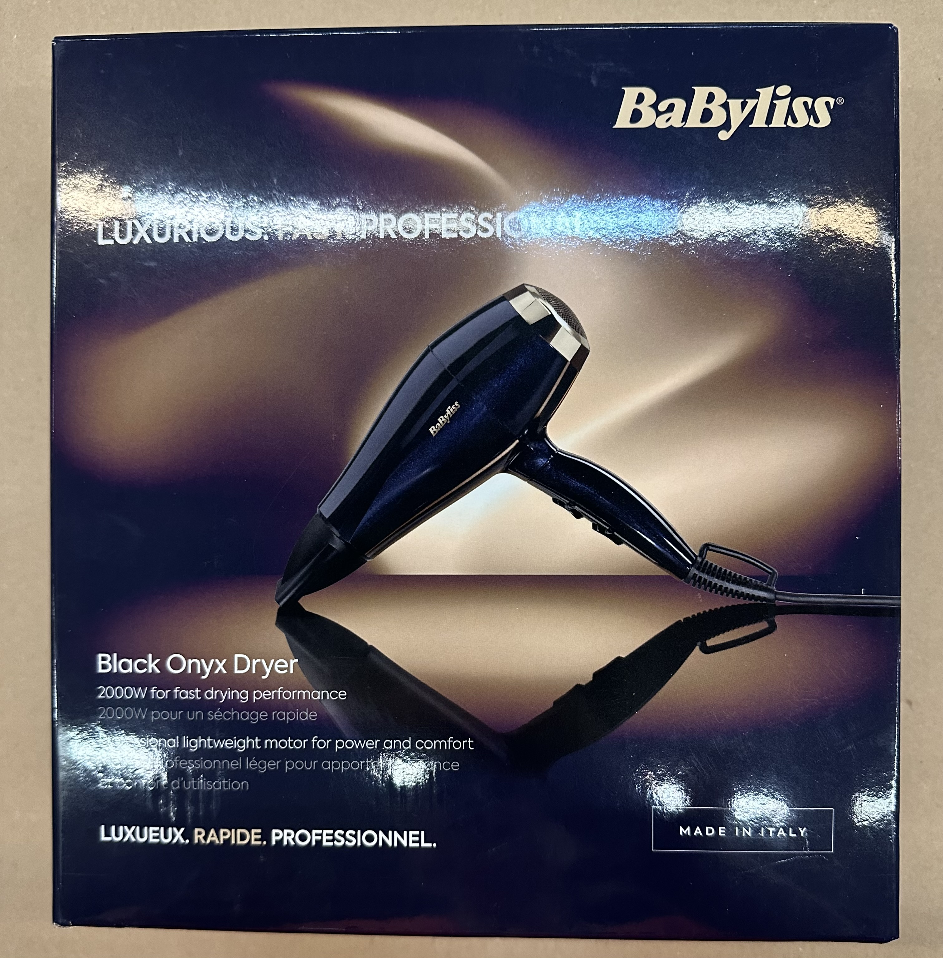 Ciemnoniebieska suszarka Babyliss na ciemnym opakowaniu z tekstem.