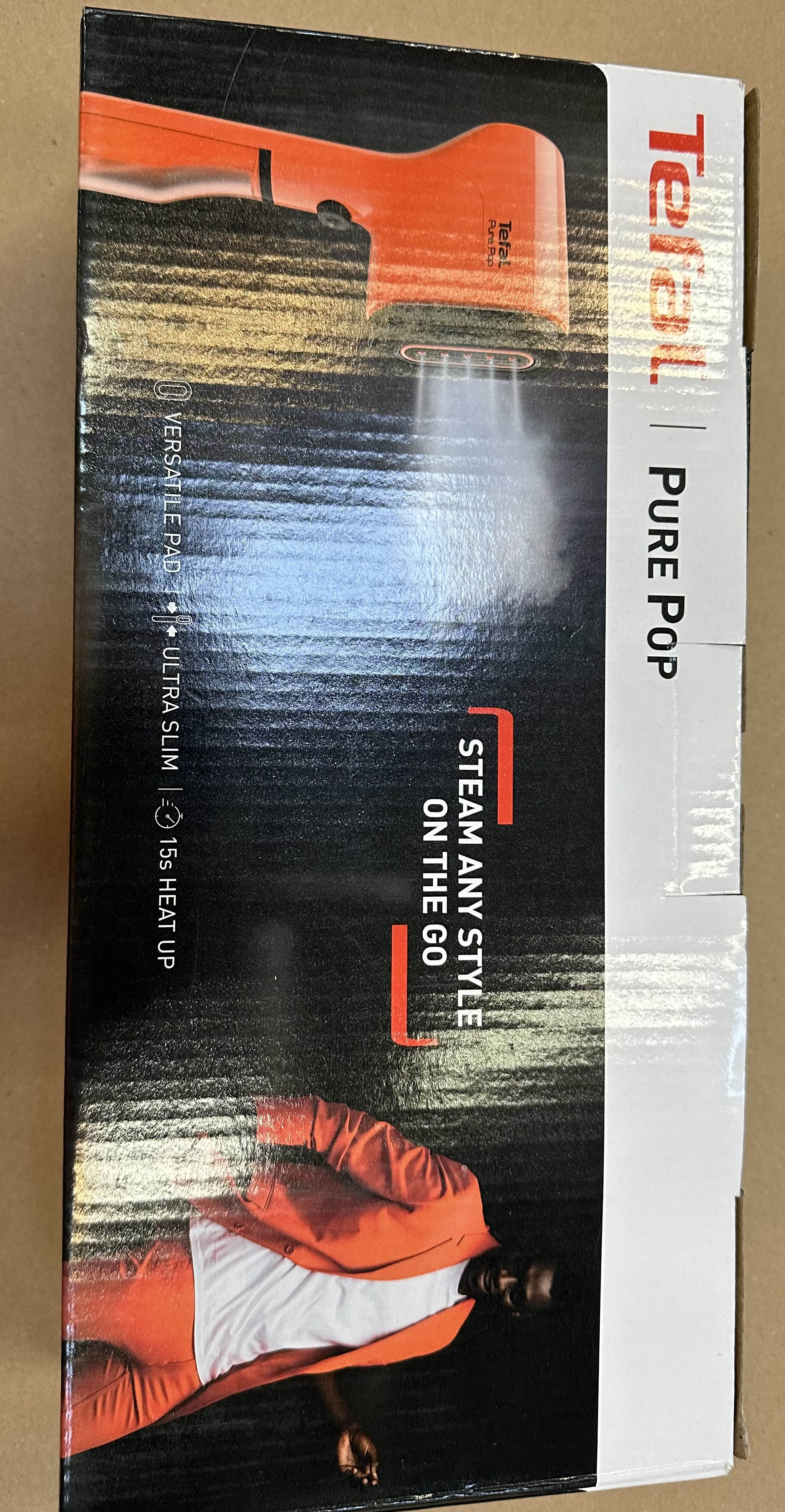 Pudełko produktu Tefal Pure Pop. Pomarańczowe tło z mężczyzną w pomarańczowym i obrazami pary.