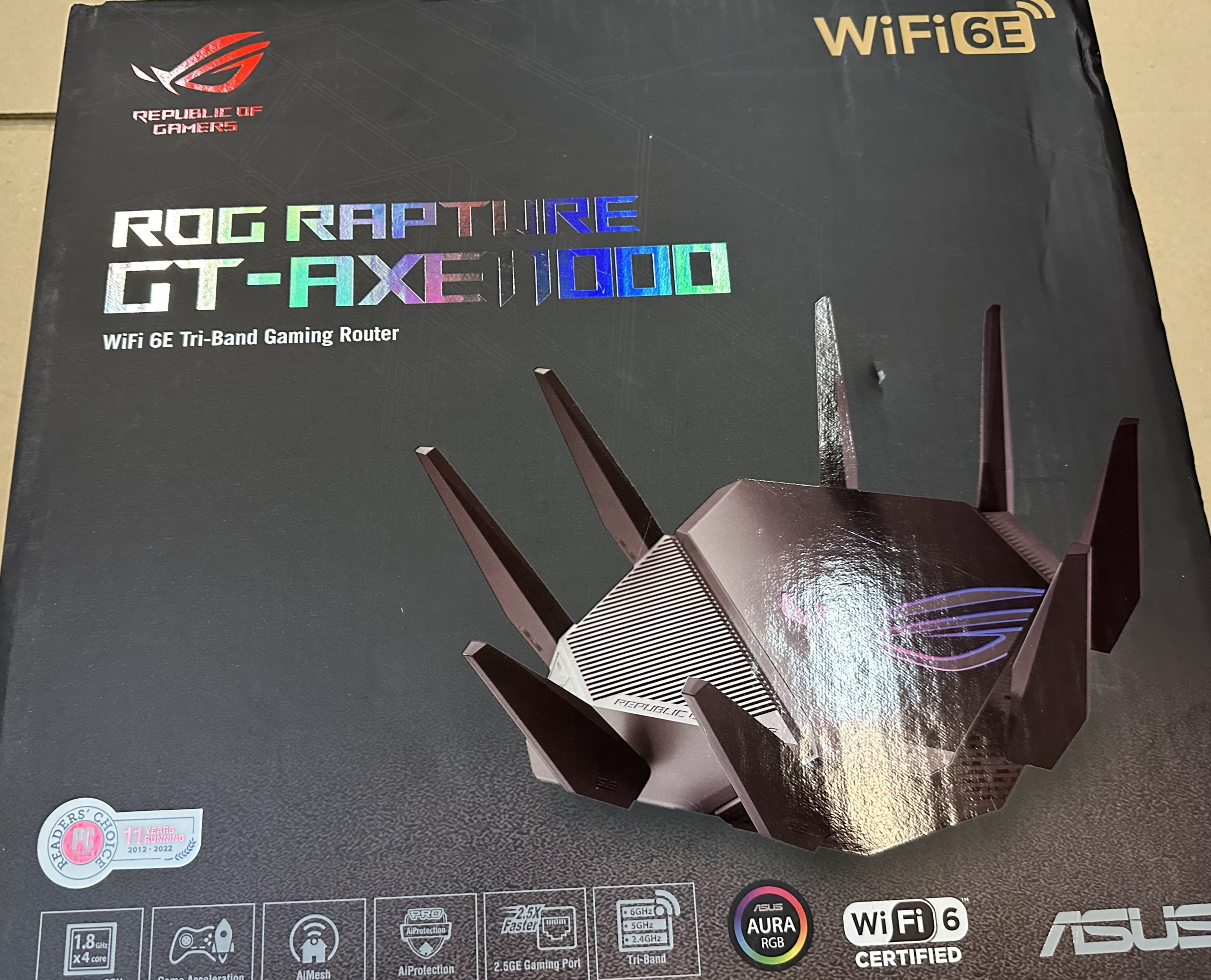 Czarne pudełko routera z logo ROG Rapture i ASUS oraz antenami.