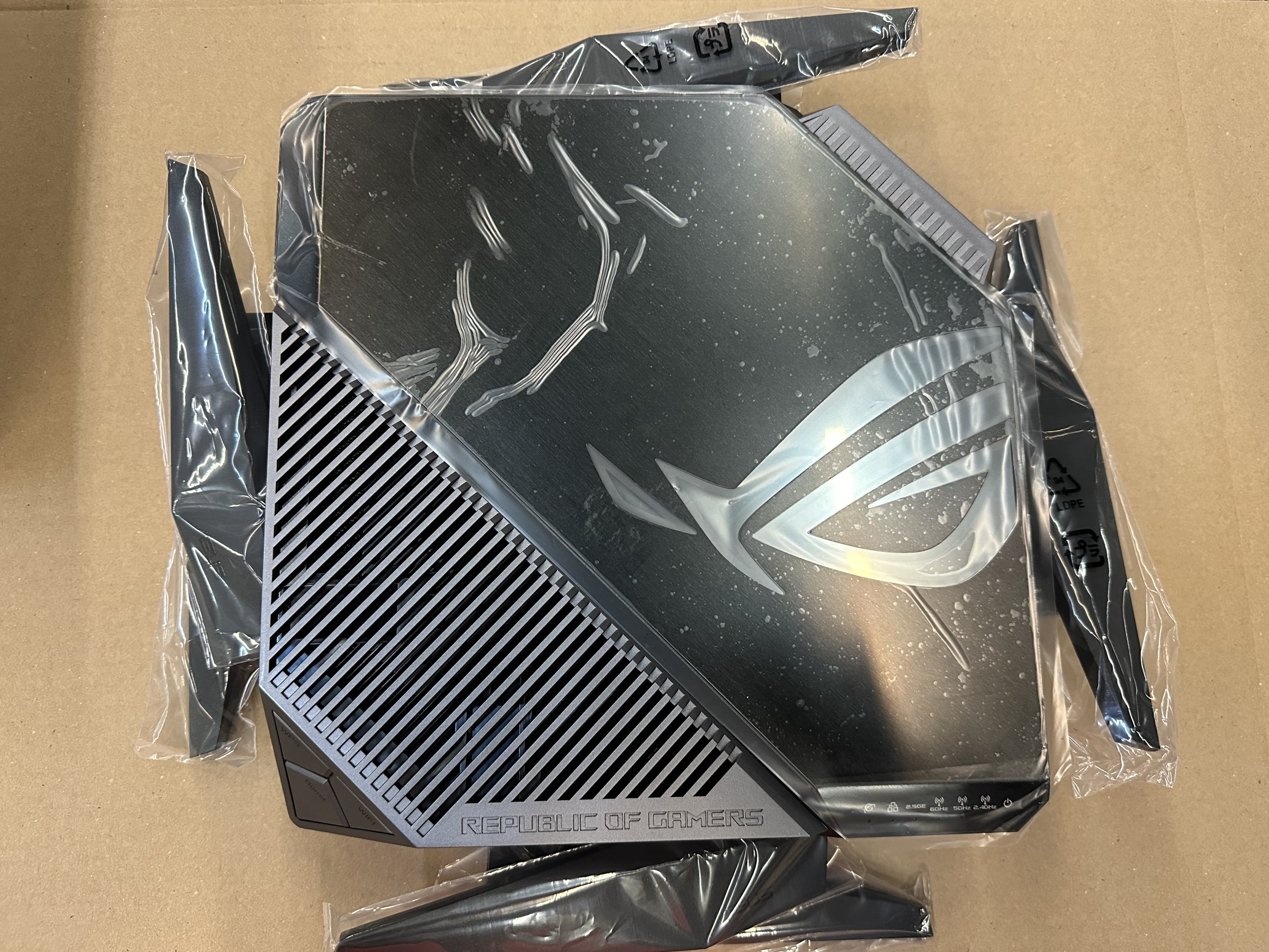 Obudowa komputera ROG w plastikowym opakowaniu. Posiada logo Republic of Gamers.