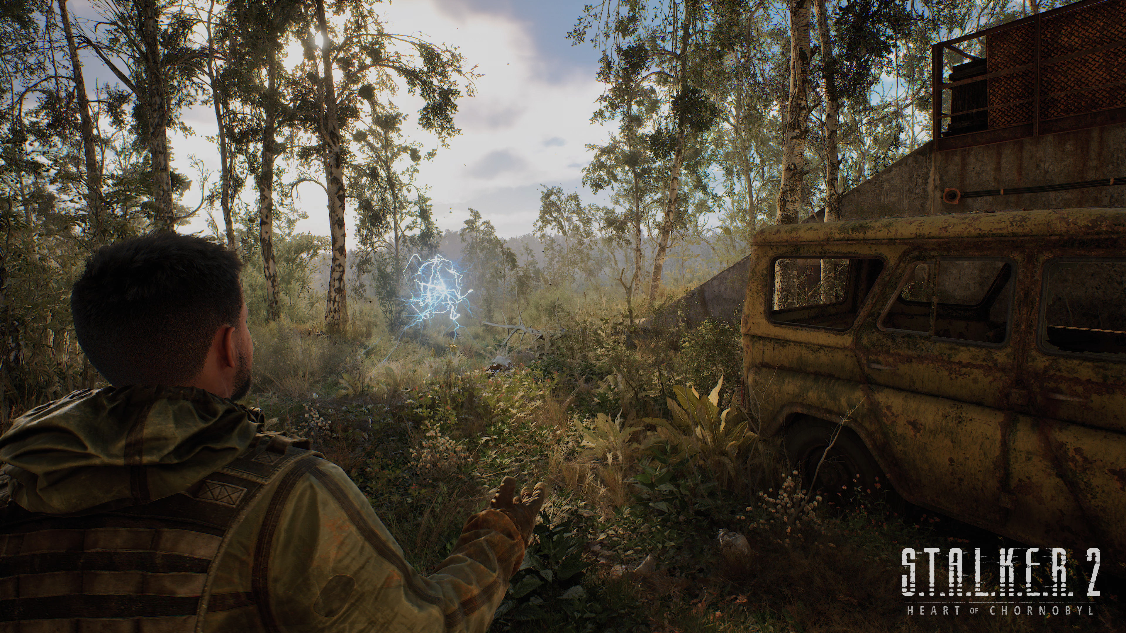 Mężczyzna w lesie wskazuje na niebieski wybuch energii. Z tyłu wrak samochodu.