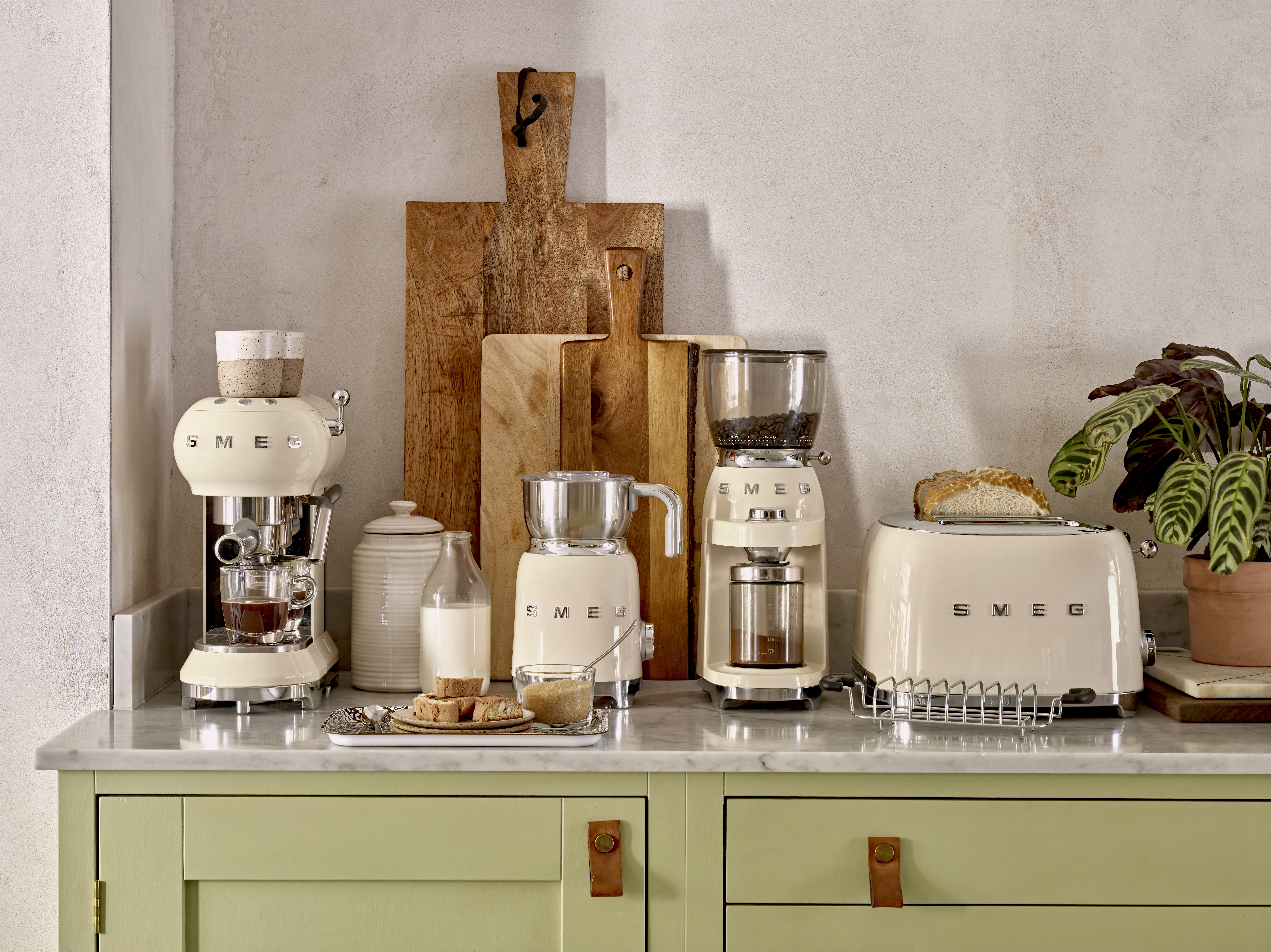 Küchengeräte auf einer Theke. Kaffeemaschine, Mühle, Toaster und Milch.