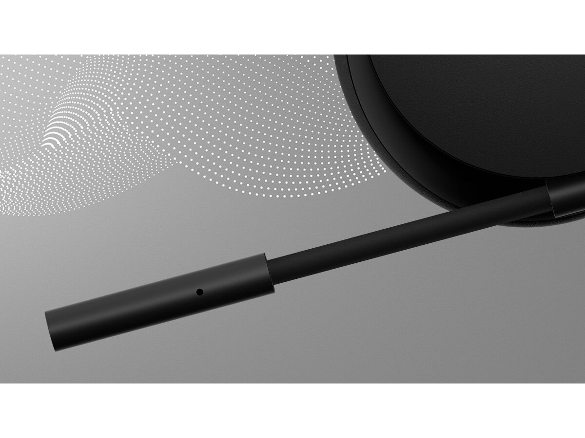 Czarne słuchawki, zbliżenie. Ramię rozciąga się od nausznika. Białe kropkowane linie w tle.