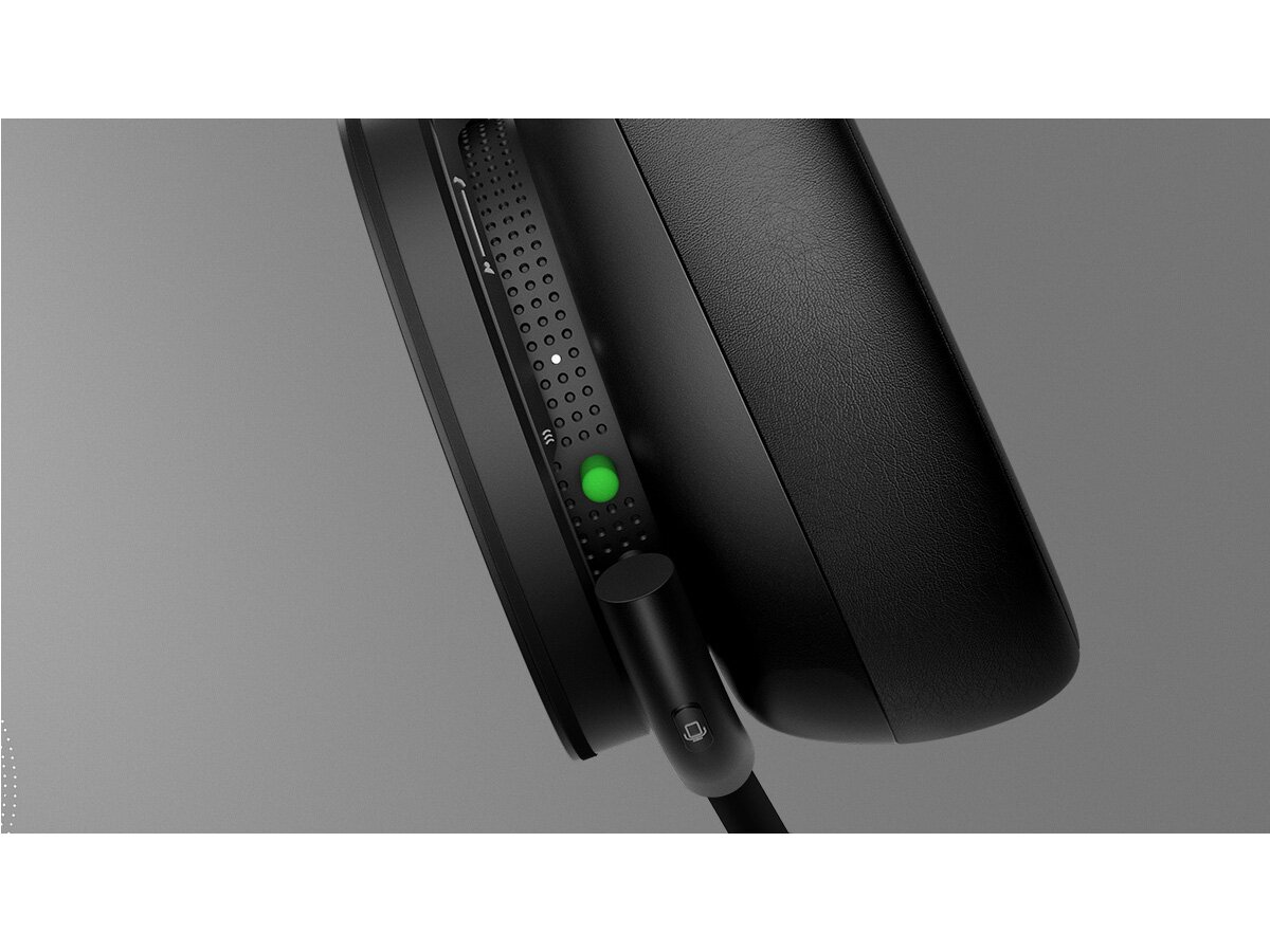 Słuchawki z kablem do ładowania i zielonym światłem wskazującym zasilanie.