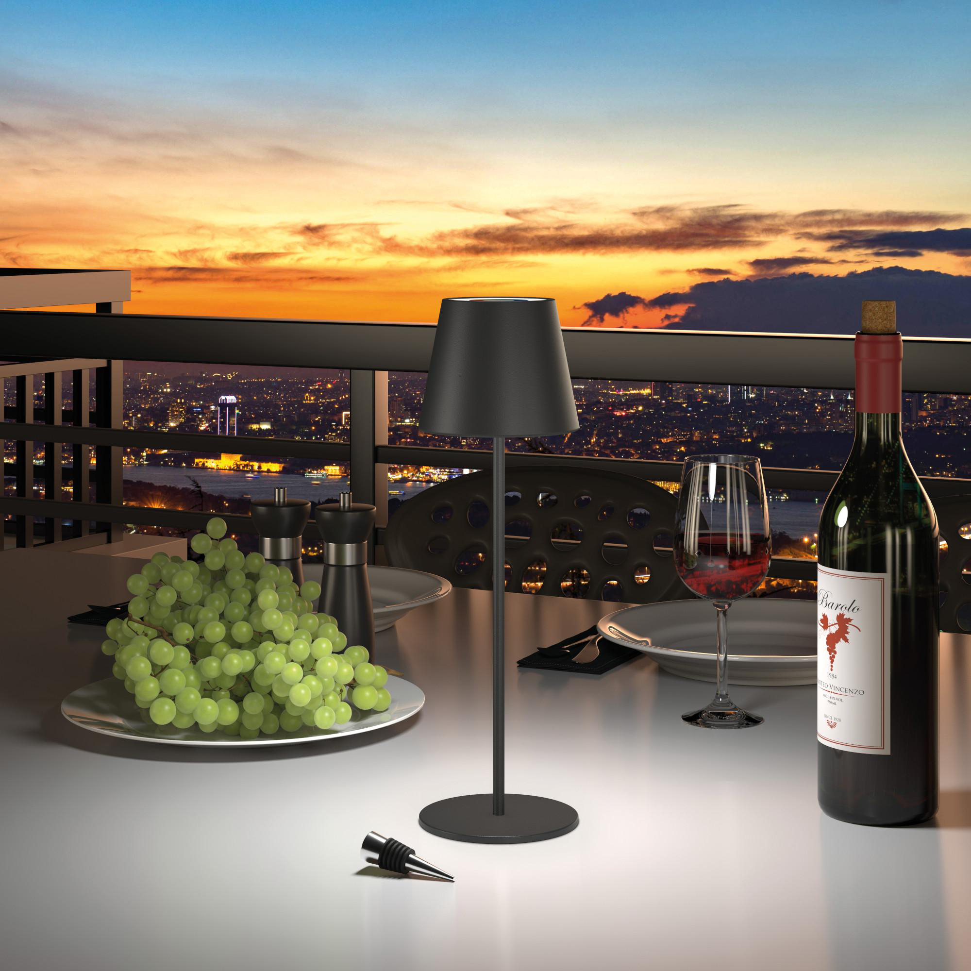 Tisch für Sonnenuntergang. Wein, Trauben, Lampe, Gläser und Skyline.