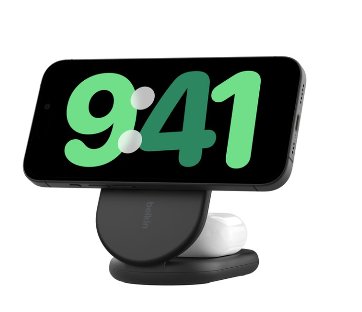 Yeşil saatli siyah telefon, beyaz AirPods ve siyah şarj standı.