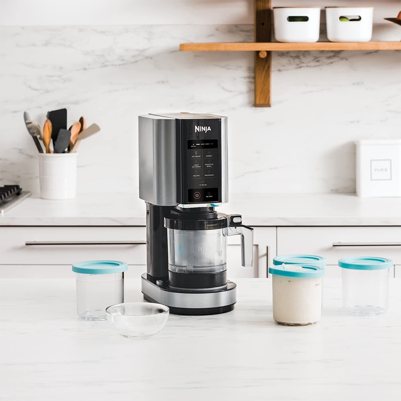Elettrodomestico da cucina argento e nero con contenitori e accessori. Ambiente cucina.