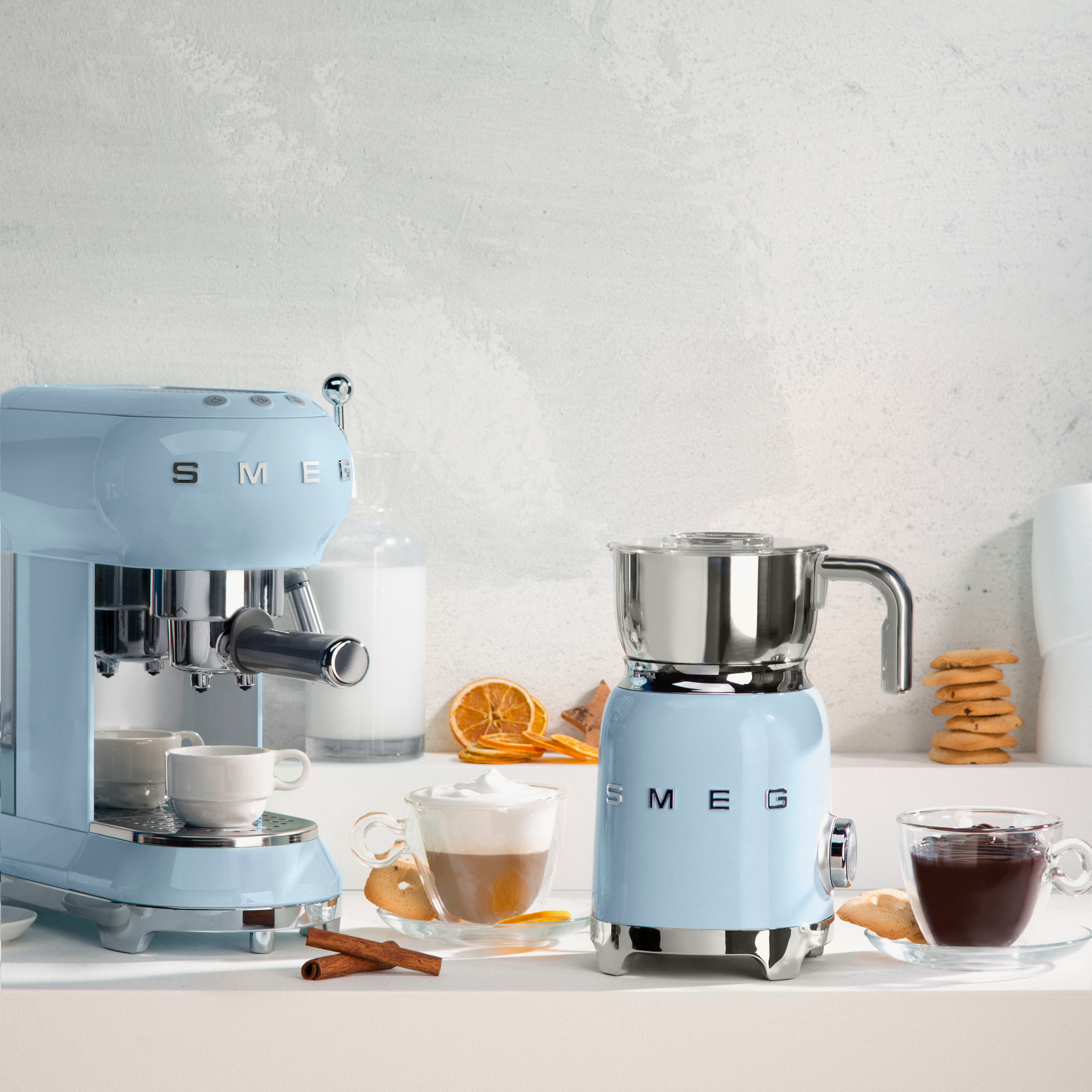 Deux machines à café SMEG bleues, une machine à expresso et un mousseur à lait.