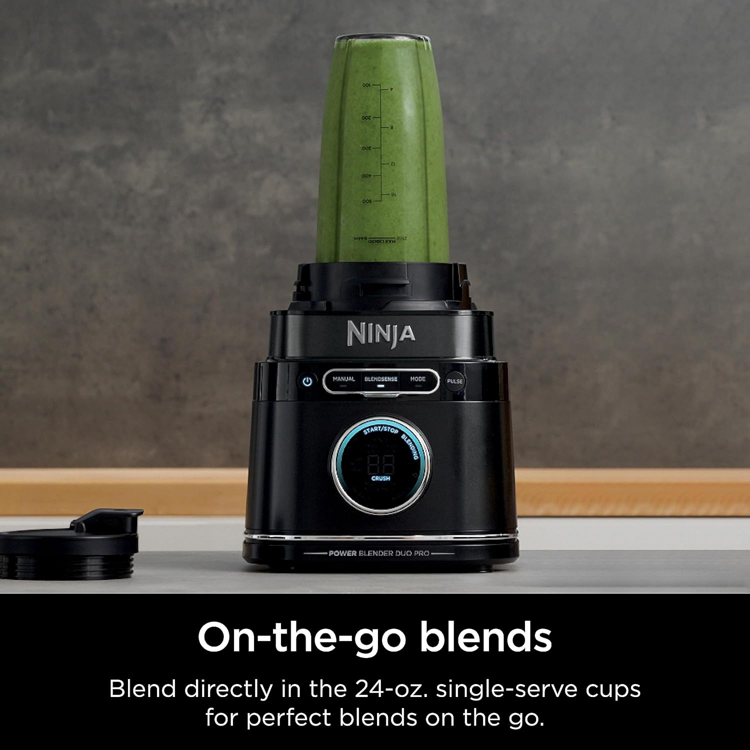 Schwarzer Ninja-Mixer mit grünem Smoothie in einem durchsichtigen Becher und Text darunter.