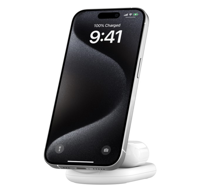 Beyaz bir taban üzerinde şarj olan bir telefon. Ekran saati gösteriyor.