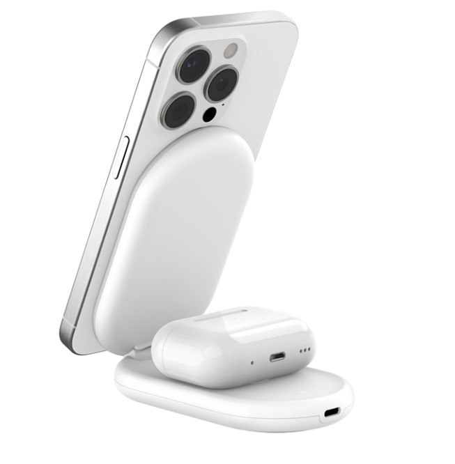 Beyaz bir telefon ve kulaklıklar bir şarj standında şarj oluyor. Stand beyaz.