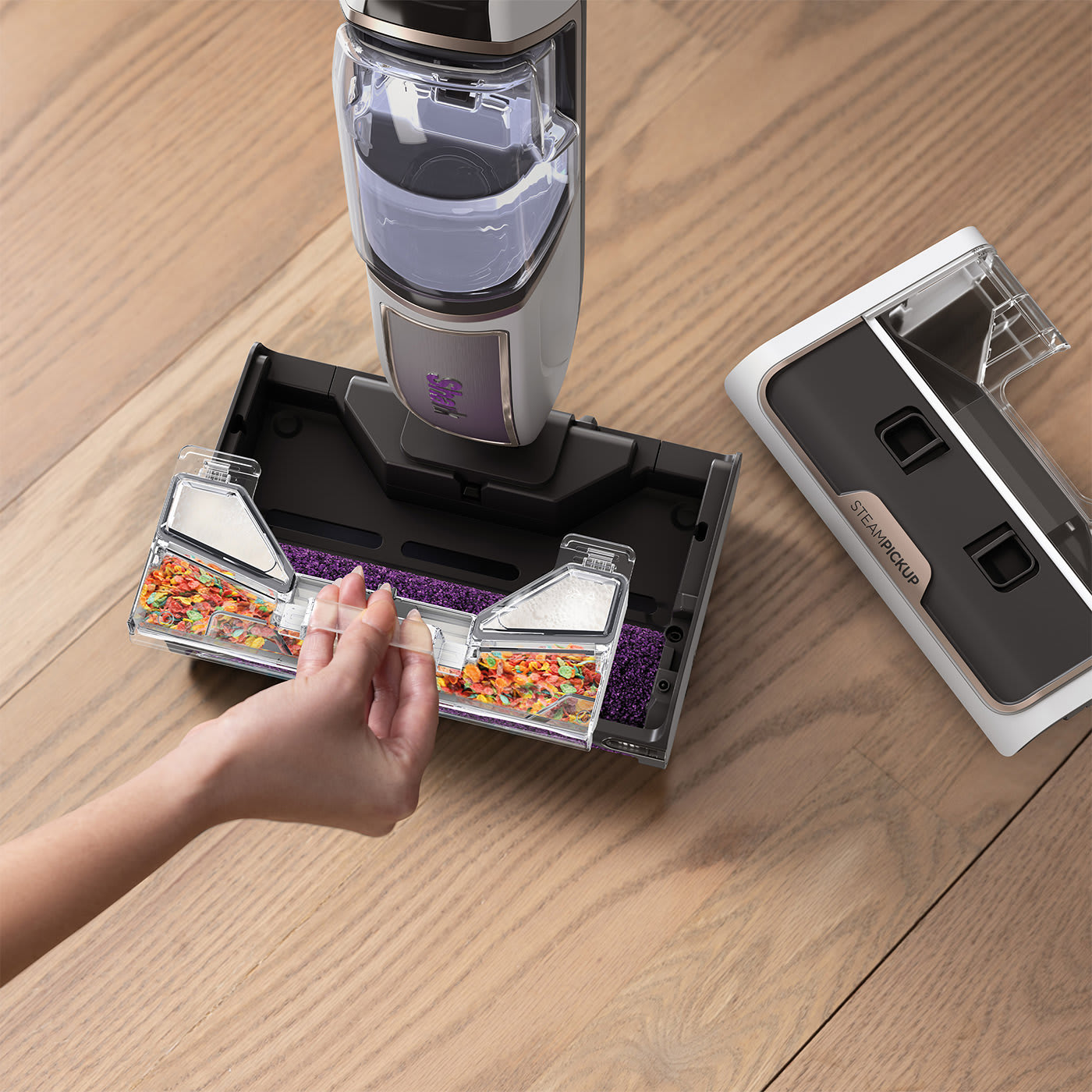 Main tenant un récipient en plastique, pièces d'aspirateur et aliments éparpillés.