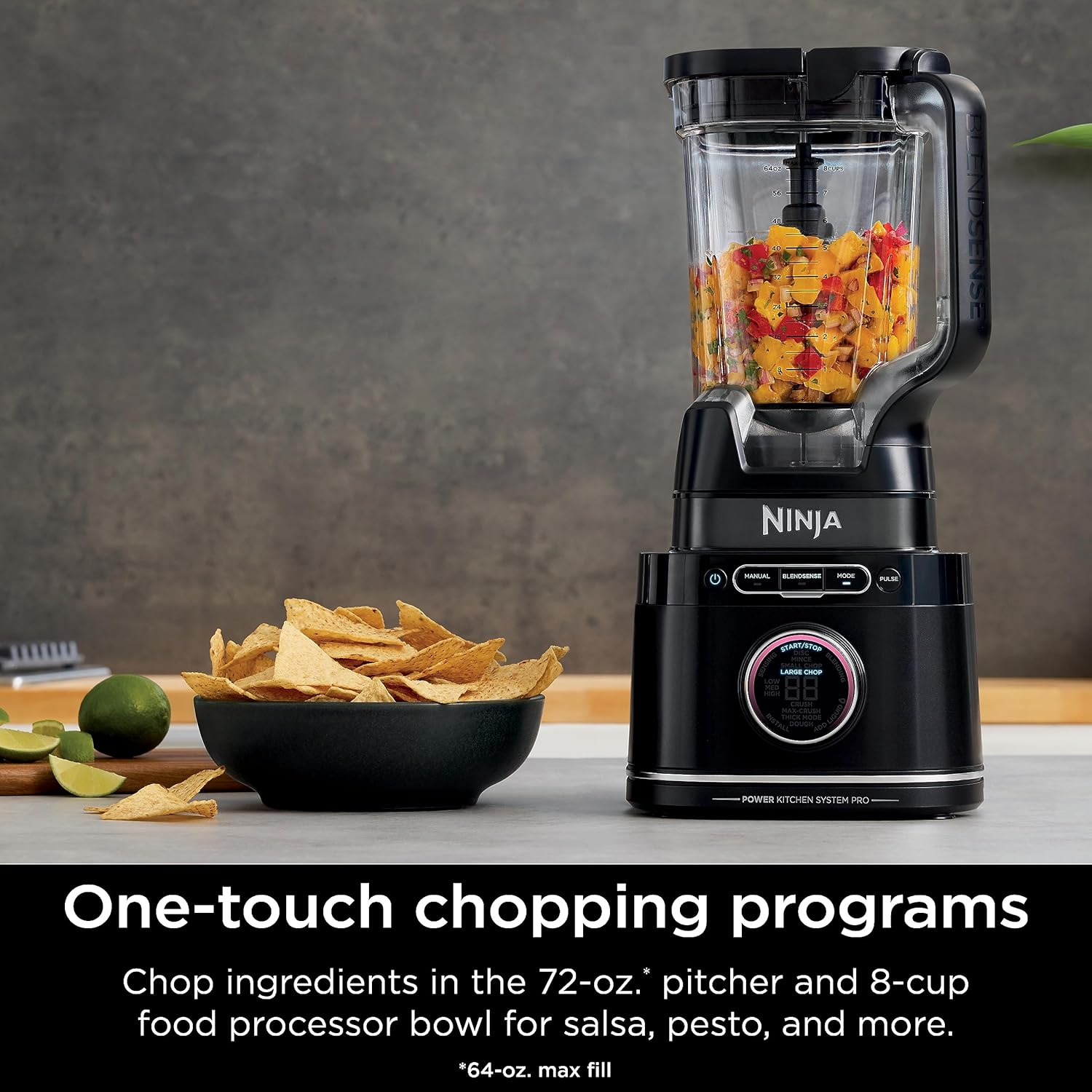 Ein Mixer mit schwarzem Sockel ist voller gehackter Früchte. Eine Schüssel mit Tortillachips und Limetten ist in der Nähe.
