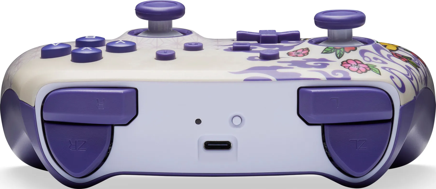 Ein weiß-violetter Gamecontroller. Es hat lila Knöpfe und Joysticks. Blumendesign an den Seiten.