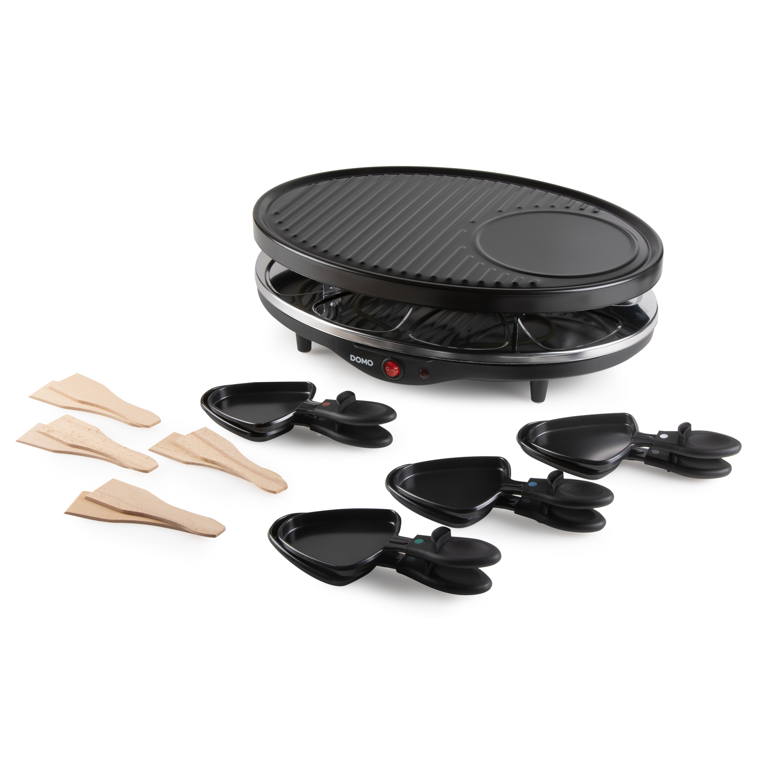 Black raclette grill with accessories. Includes spatulas and small pans. White background.