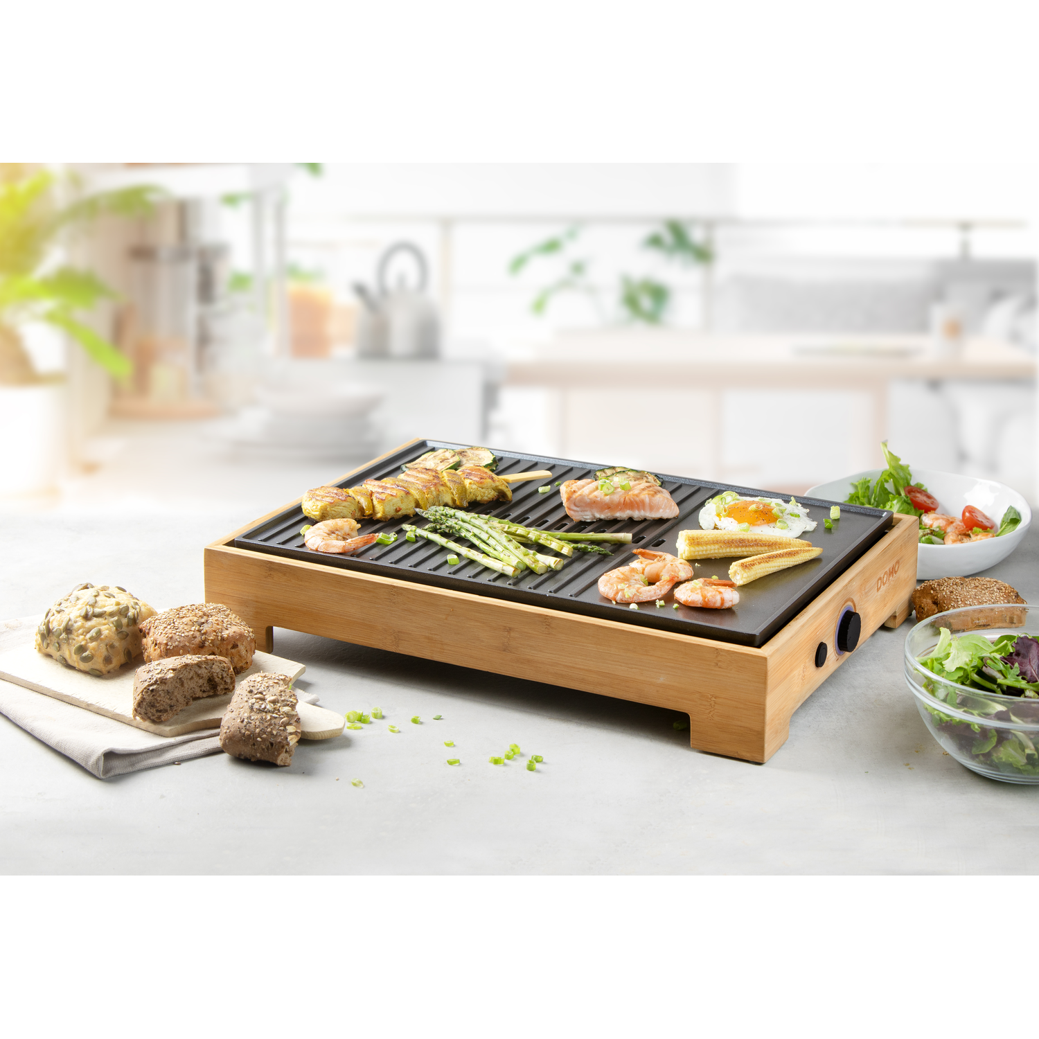 Raclette grill met eten. Het heeft een houten basis, met gegrild eten en groenten. Saladeschalen staan ernaast.