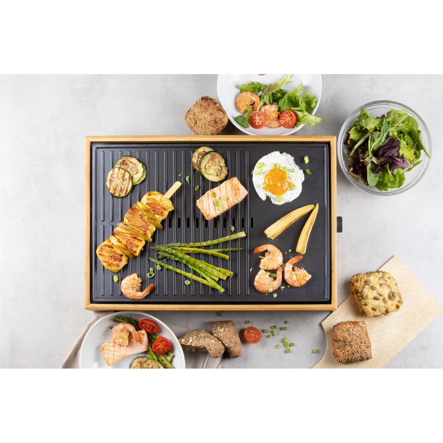 Eten op een grill: gegrilde groenten, garnalen en salade.