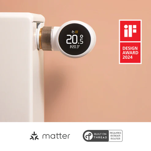 Un termostato inteligente blanco muestra 20,5 grados. Está conectado a un radiador blanco. Es visible un logotipo del premio de diseño if.