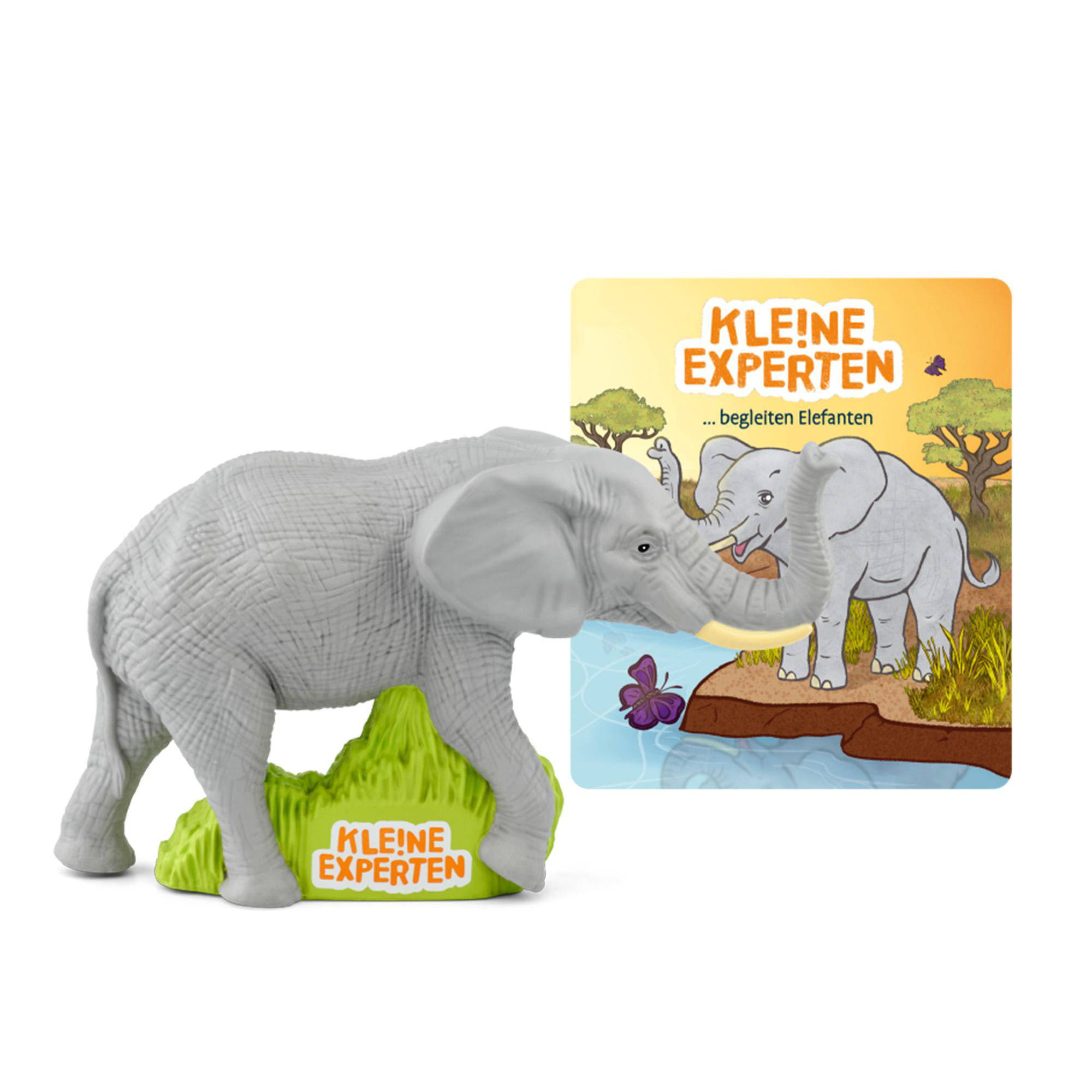 Ein graues Elefantenspielzeug auf Grün, mit zwei grauen Haifischflossen.
