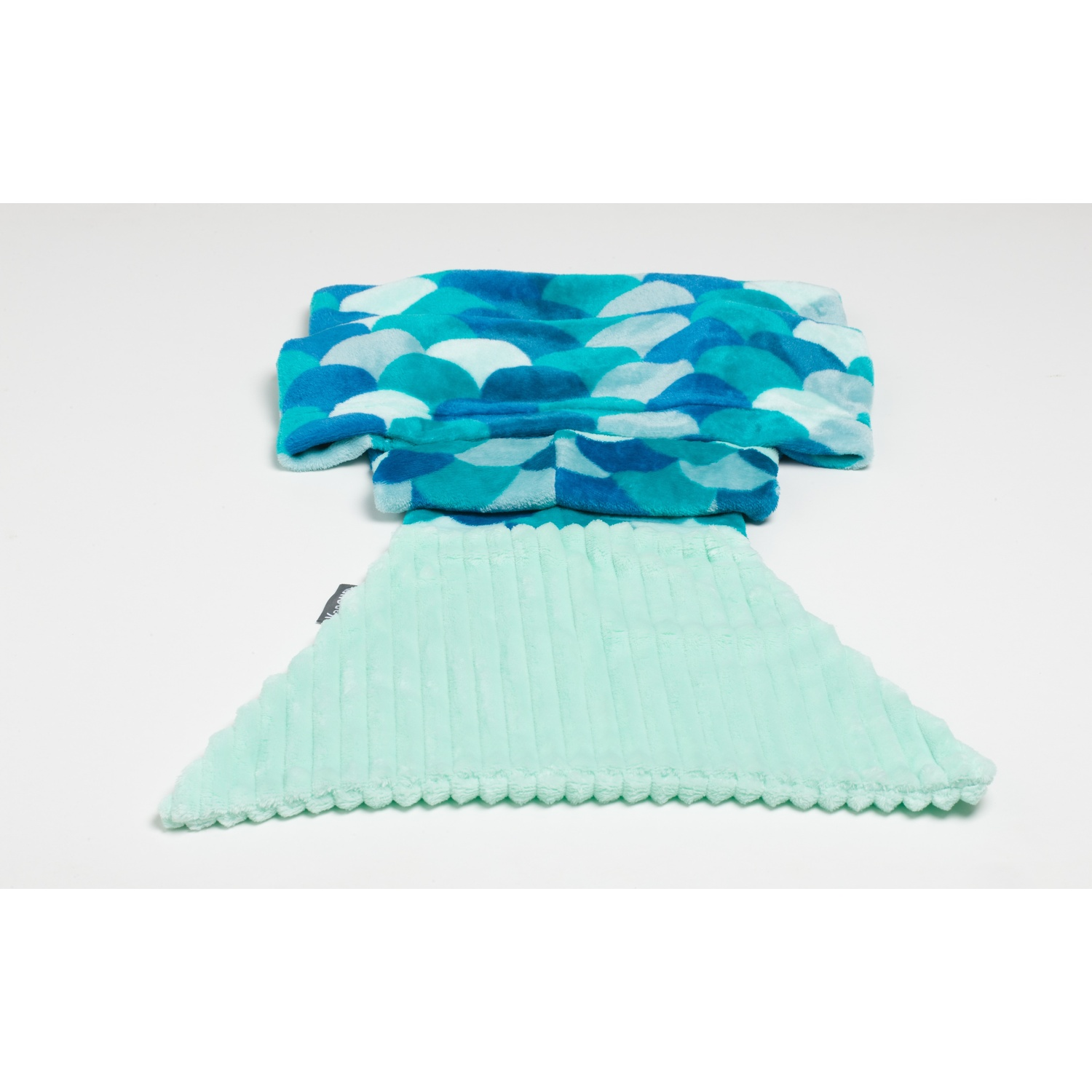 Coperta a coda di sirena blu e verde. La coda è verde menta. Sfondo bianco.