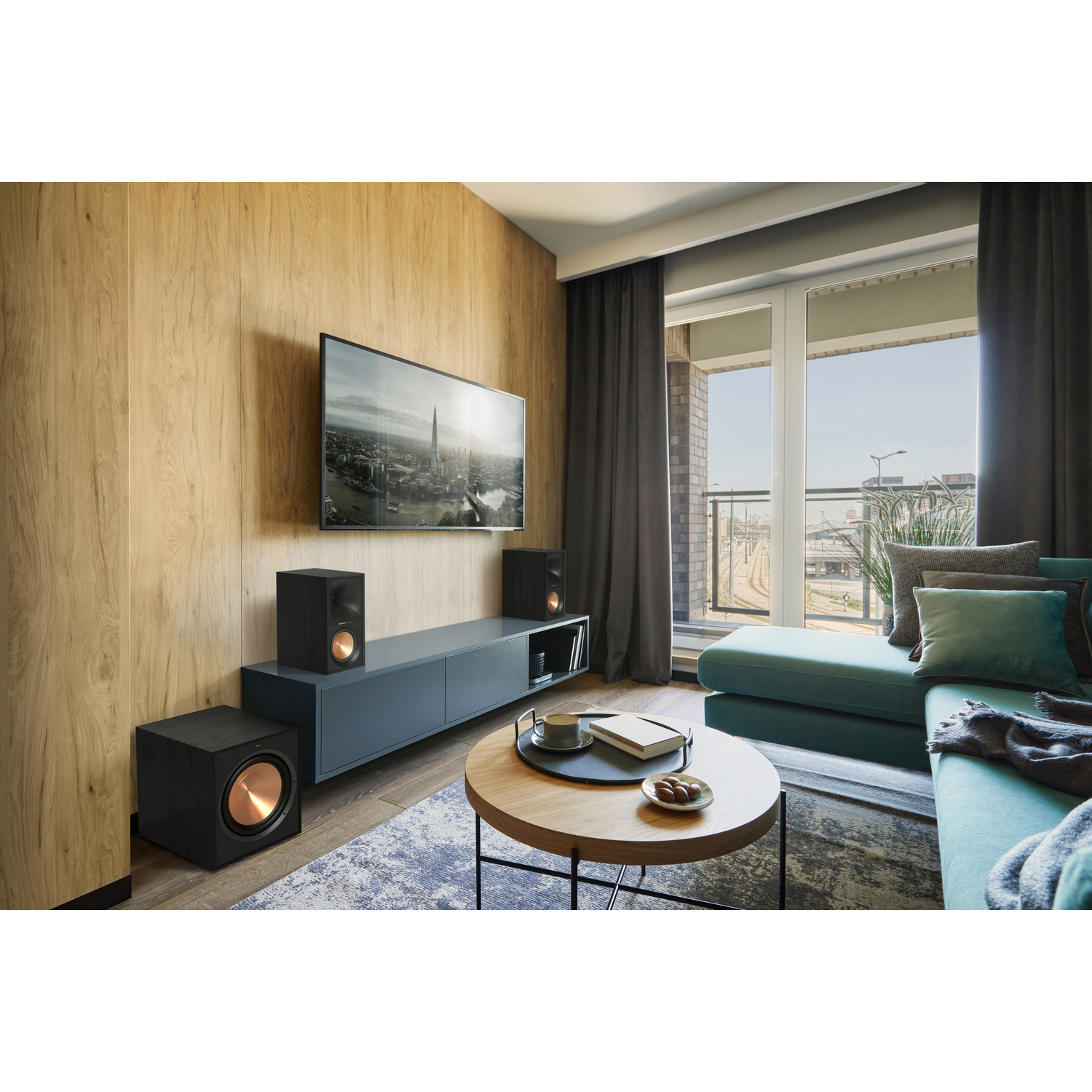 A living room setup with a TV, speakers, and a sofa.