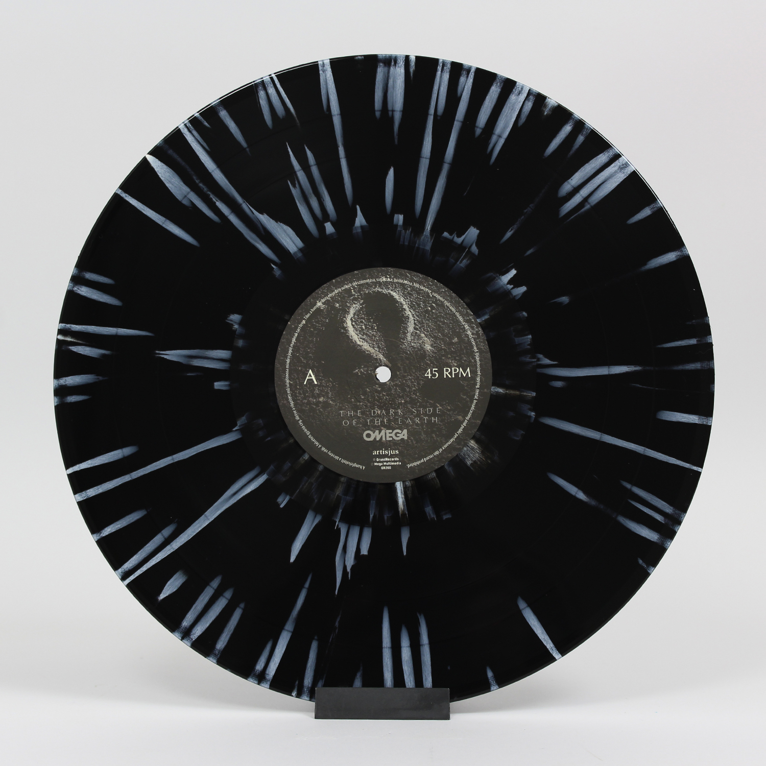 Fekete-fehér bakelit lemez fehér fröccsenésekkel. Szövegfelirat és 45 RPM.