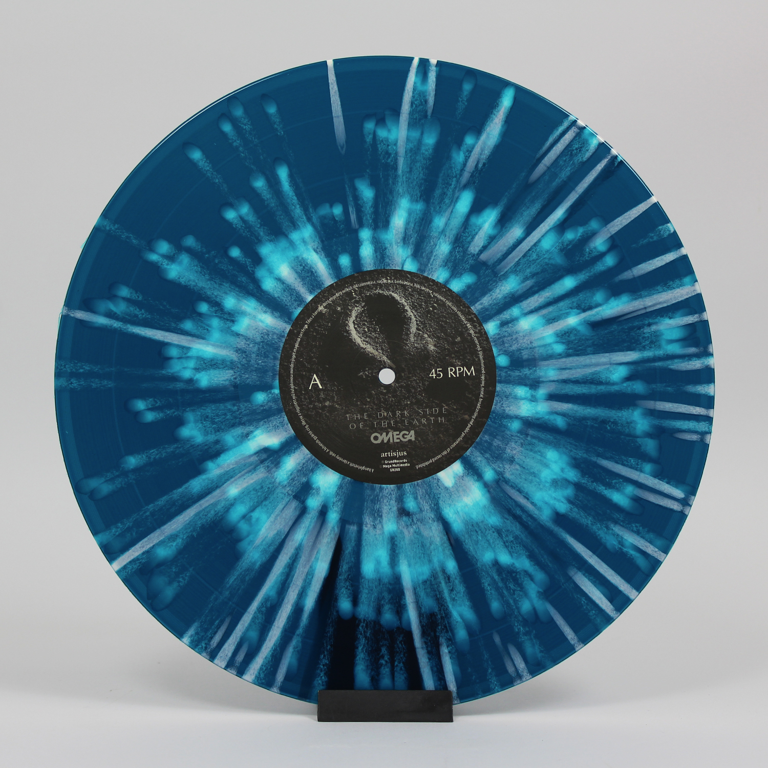 Kék-fehér bakelit lemez fehér fröccsenésekkel. Szövegfelirat és 45 RPM.