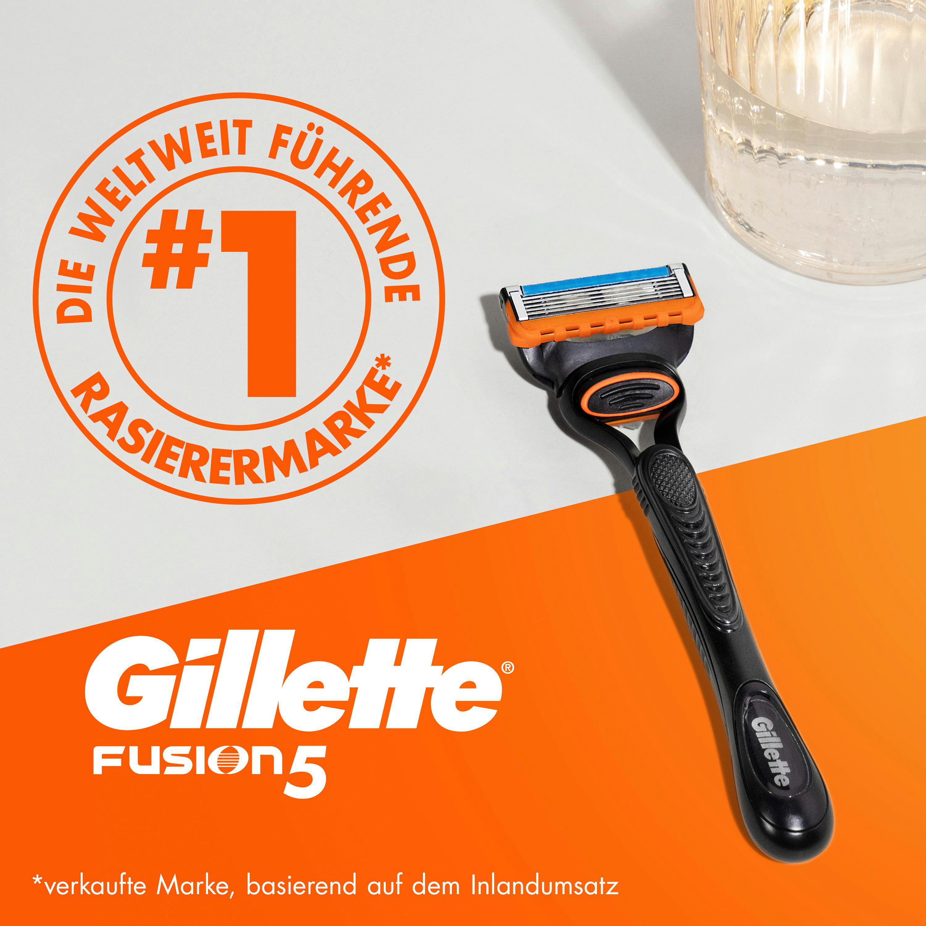 Ein schwarzer Rasierer mit orangefarbenen und blauen Klingen. Das Wort Gillette ist in Weiß geschrieben.