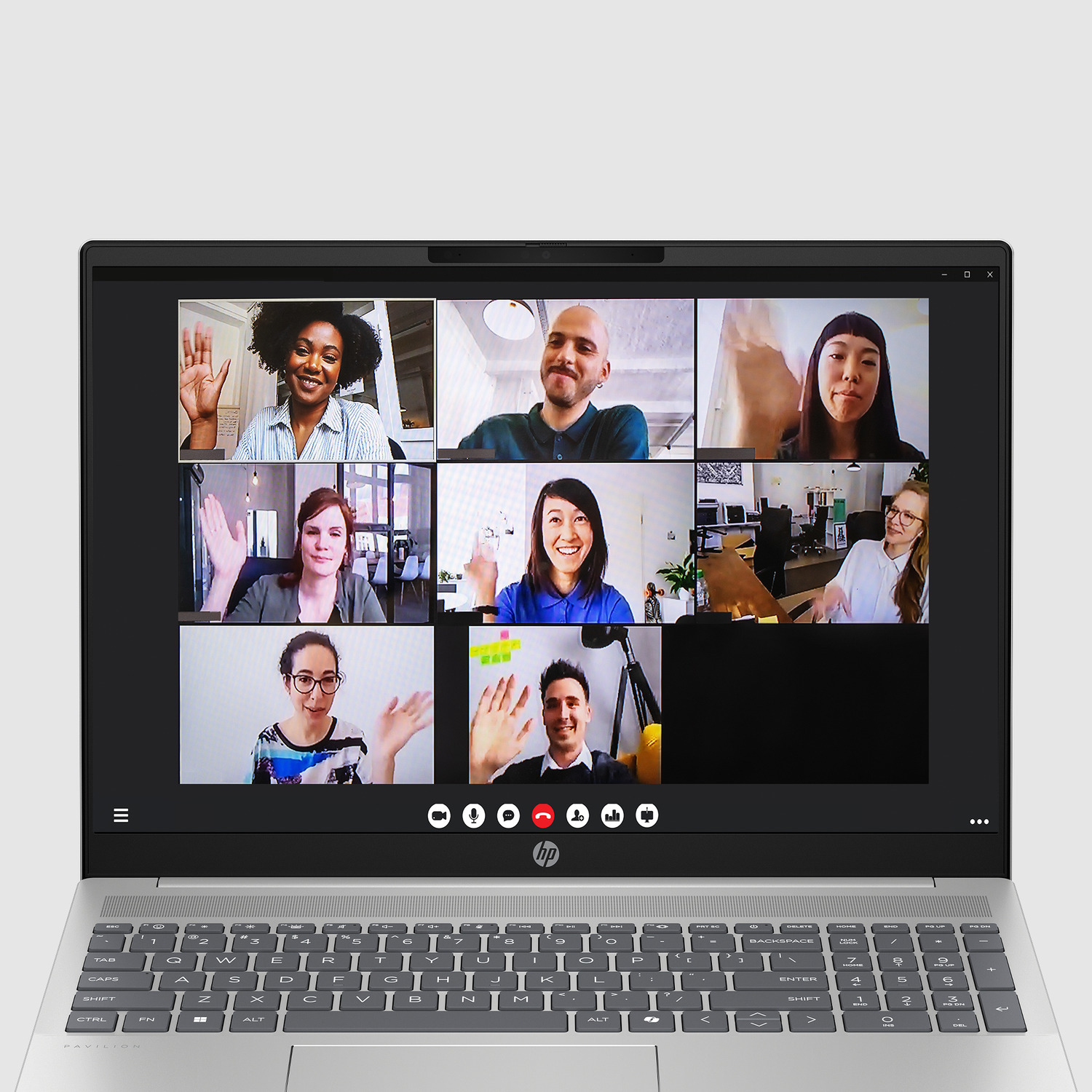 A laptop screen shows a video call with eight people waving.