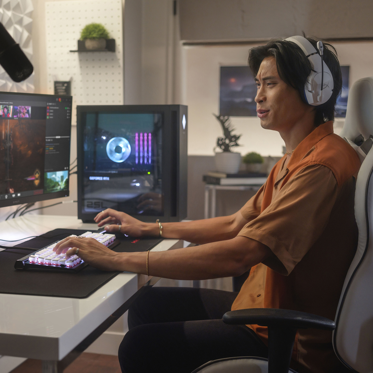 Een man gamet aan een bureau met twee monitoren, toetsenbord en pc. Hij draagt een headset.