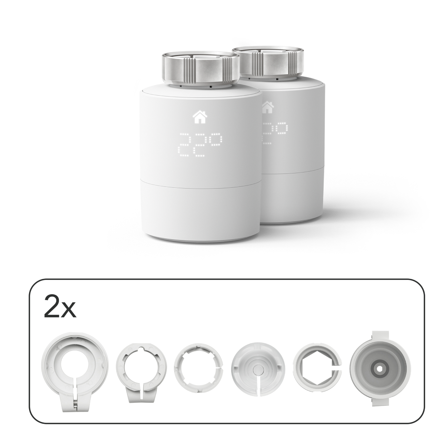 Dos termostatos inteligentes blancos con pantallas digitales y un juego de adaptadores de montaje blancos.