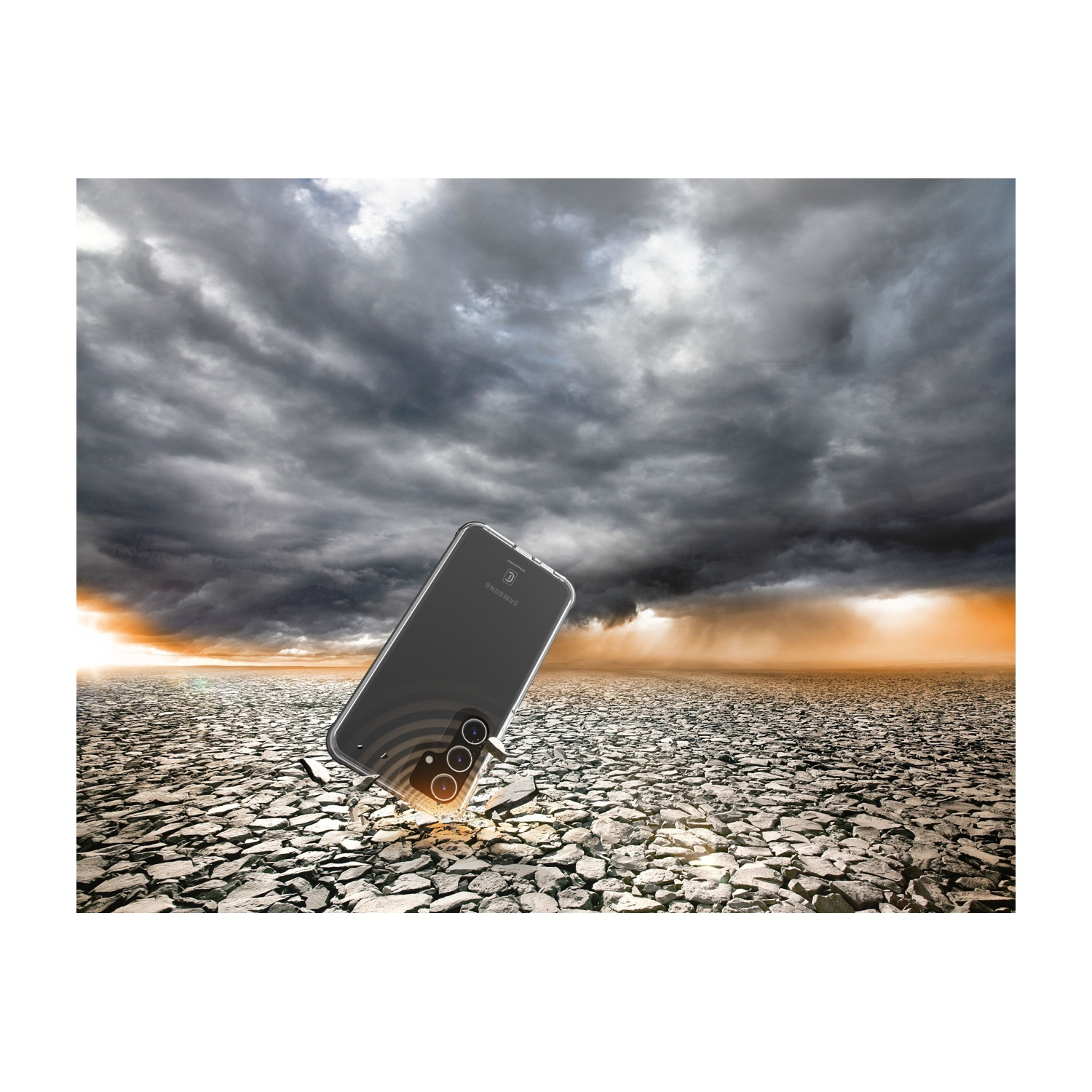 Un telefono in una custodia trasparente fluttua in un paesaggio crepato sotto un cielo drammatico. Samsung.