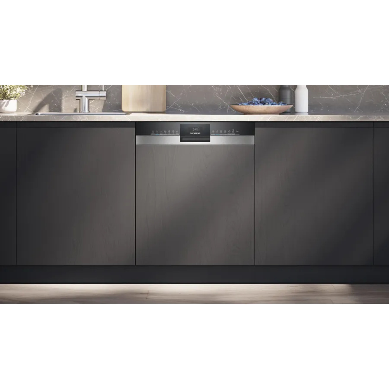 Lave-vaisselle Siemens dans une cuisine. Meubles sombres, un comptoir et un bol de myrtilles.