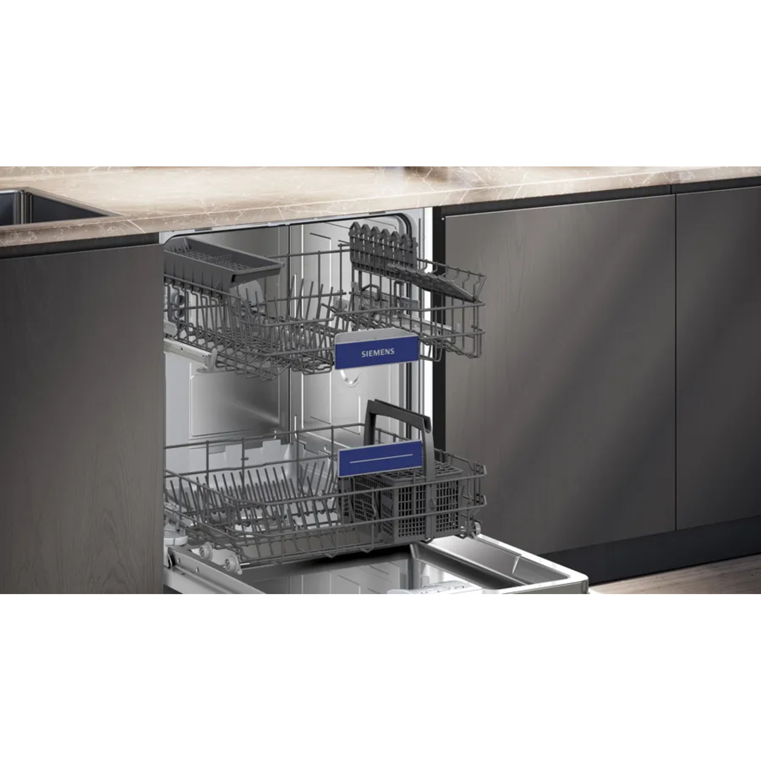 Open dishwasher with two racks visible. Racks are gray. Blue Siemens labels are visible. Dark wooden cabinets surround.
