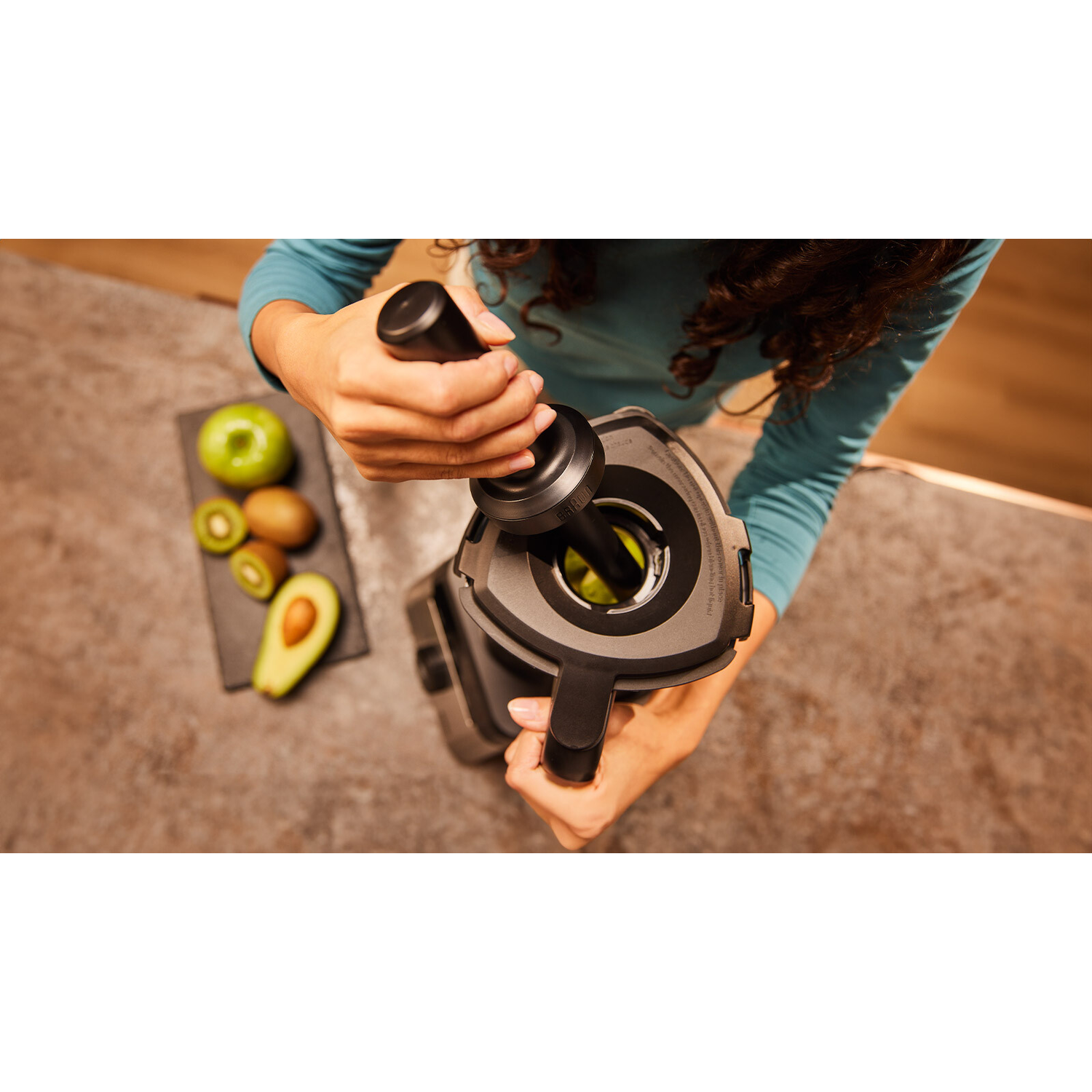 Overhead shot of a blender being prepared with fruits.