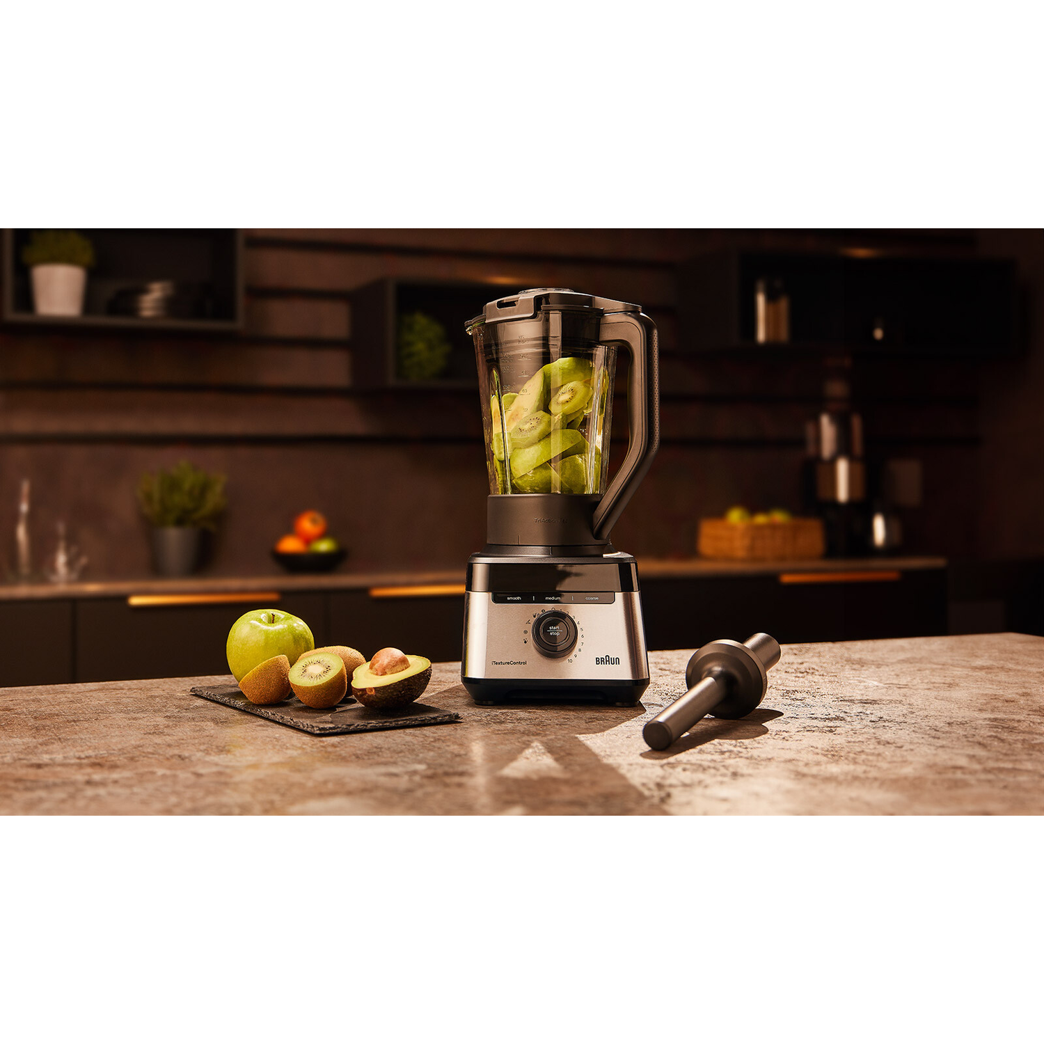 Blender with kiwi in the jar, green apple, kiwi, and avocado.